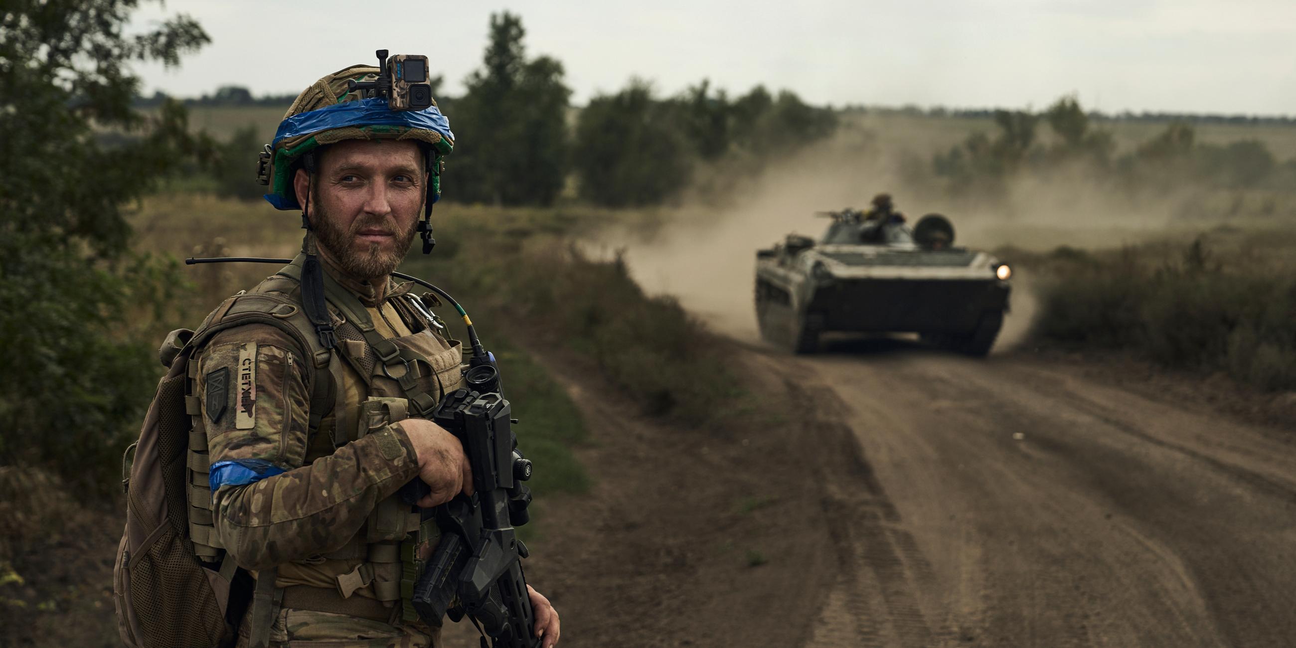 Ukraine, Bachmut: Ein Soldat der 3. Separatistenbrigade der Ukraine blickt auf einen Schützenpanzer.