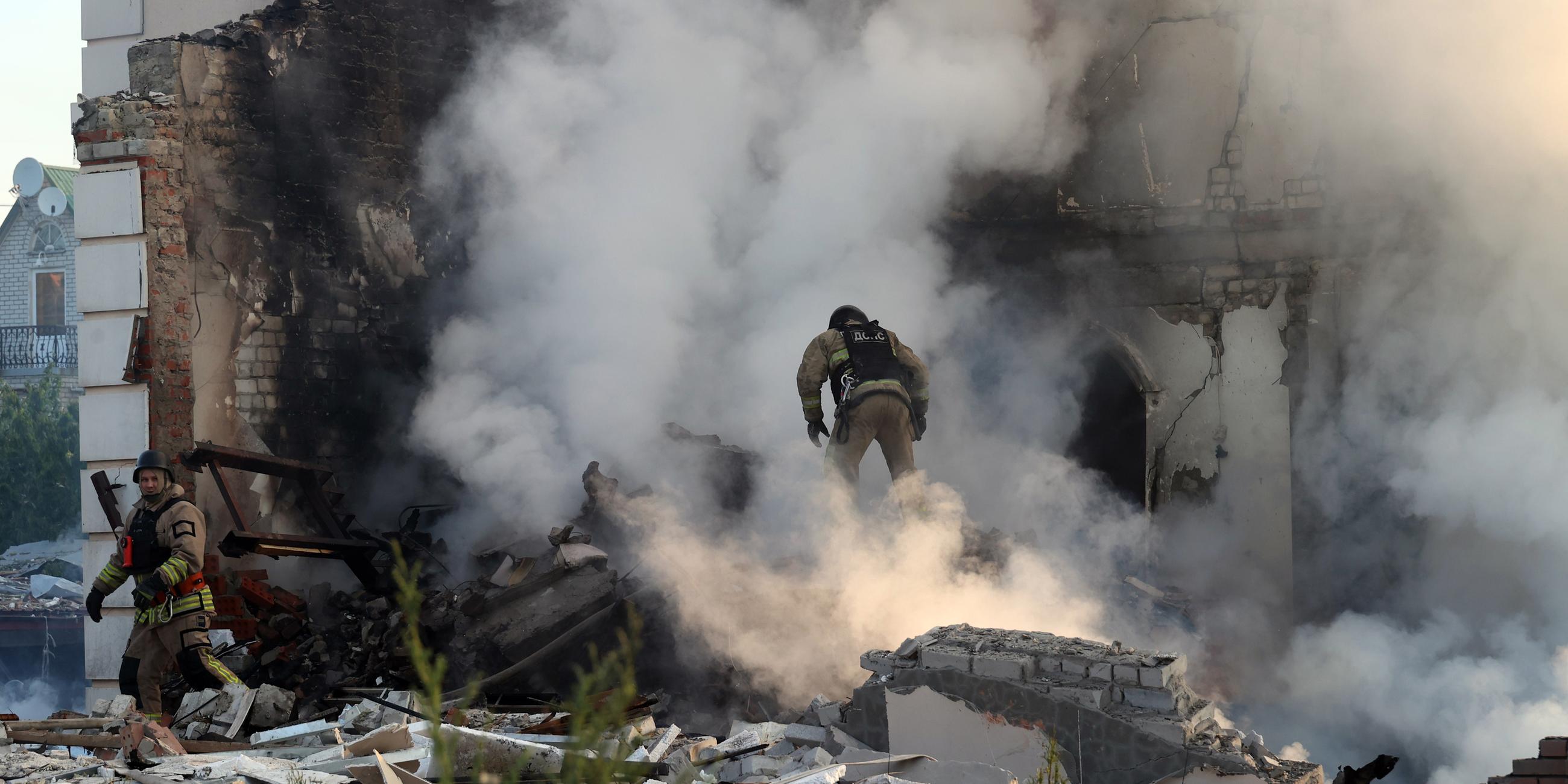 Ukraine, Charkow: Ein Feuerwehrmann geht durch den Qualm eines brennenden Hauses, nach russischen Beschuss.