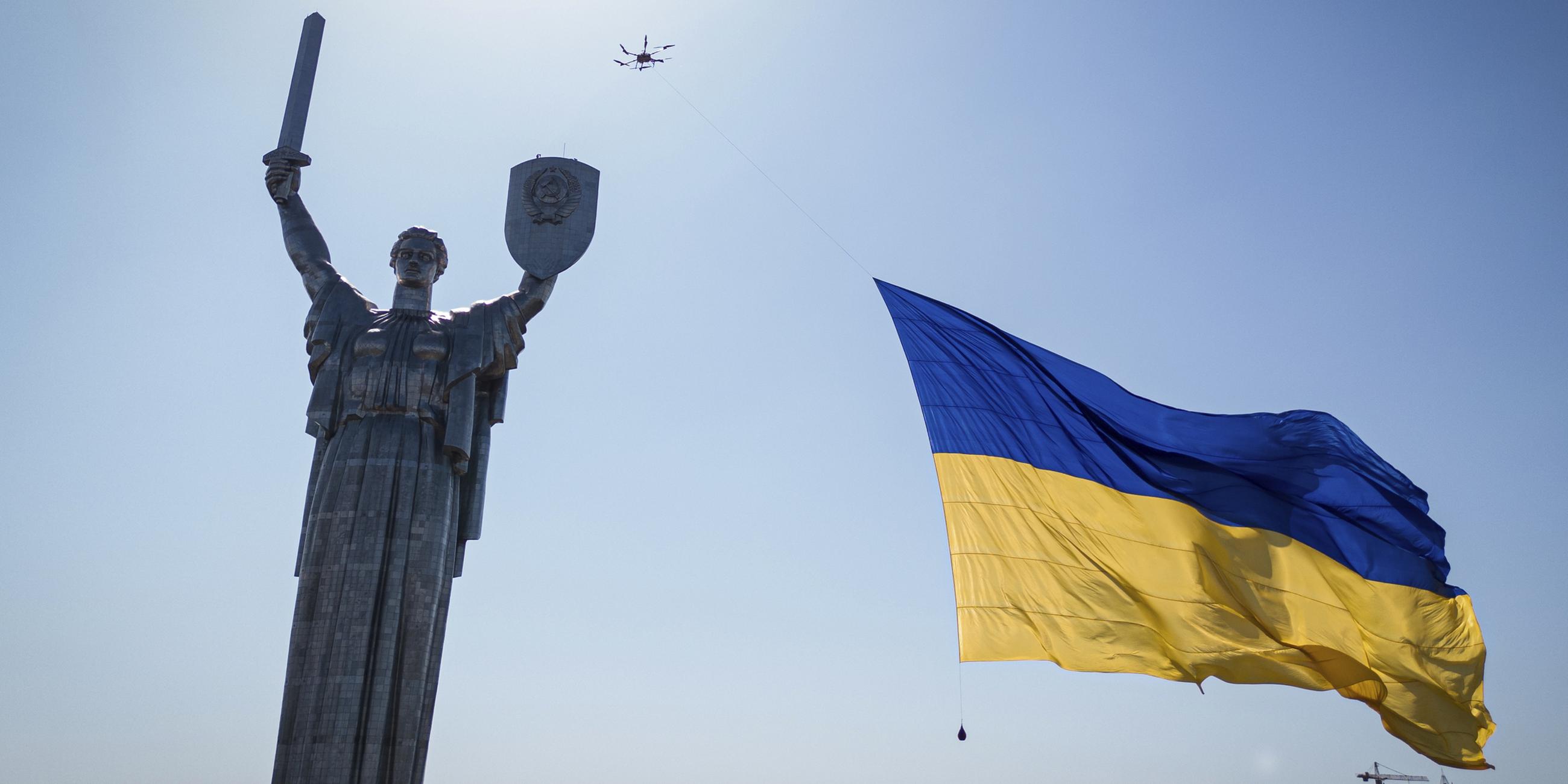 Eine Drohne trägt eine große Nationalfahne vor dem ukrainischen Mutterland-Denkmal, am Tag der Unabhängigkeit der Ukraine. 