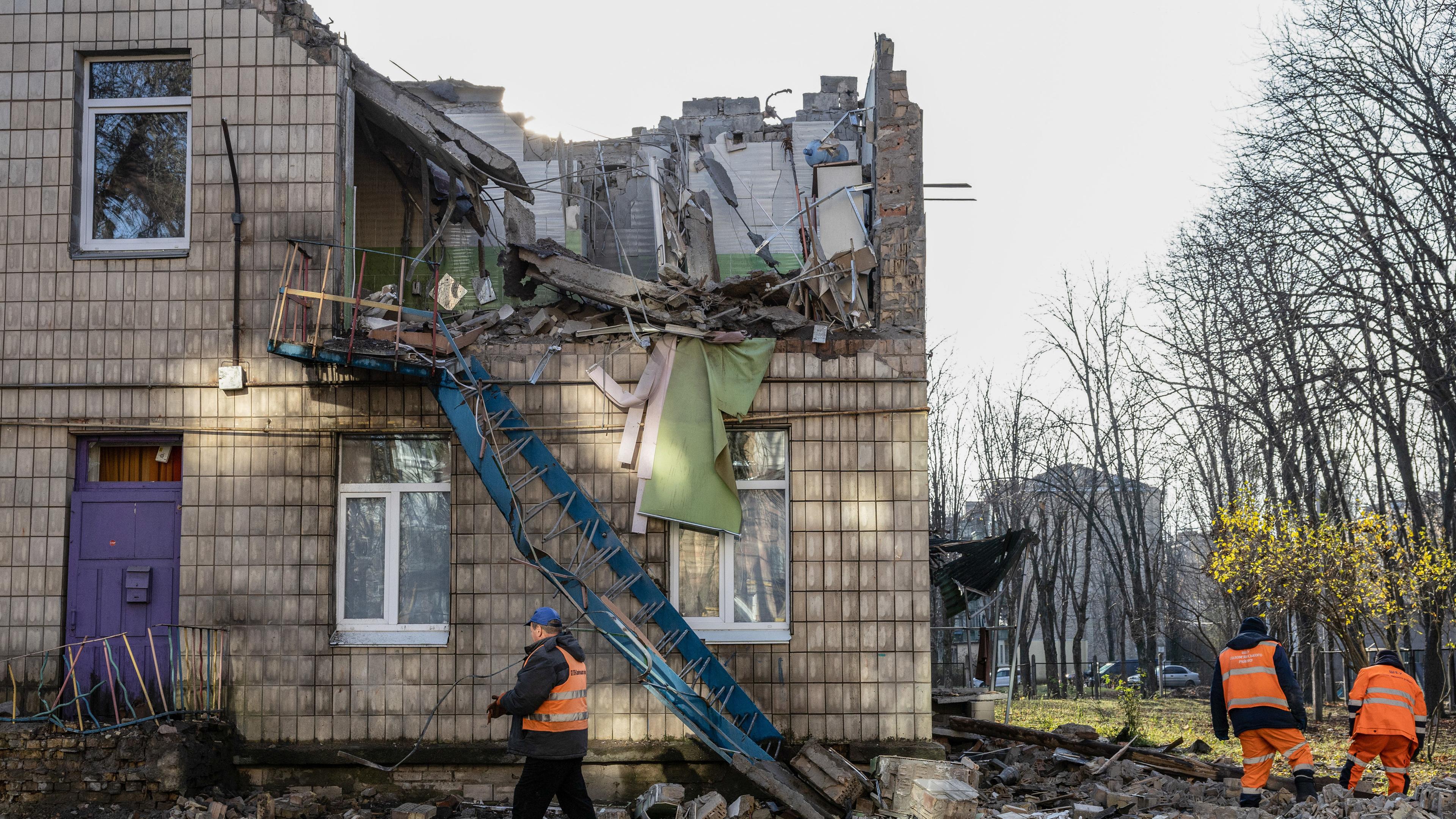 Arbeiter räumen die Trümmer eines von einer russischen Drohne zerstörten Kindergartens auf. 