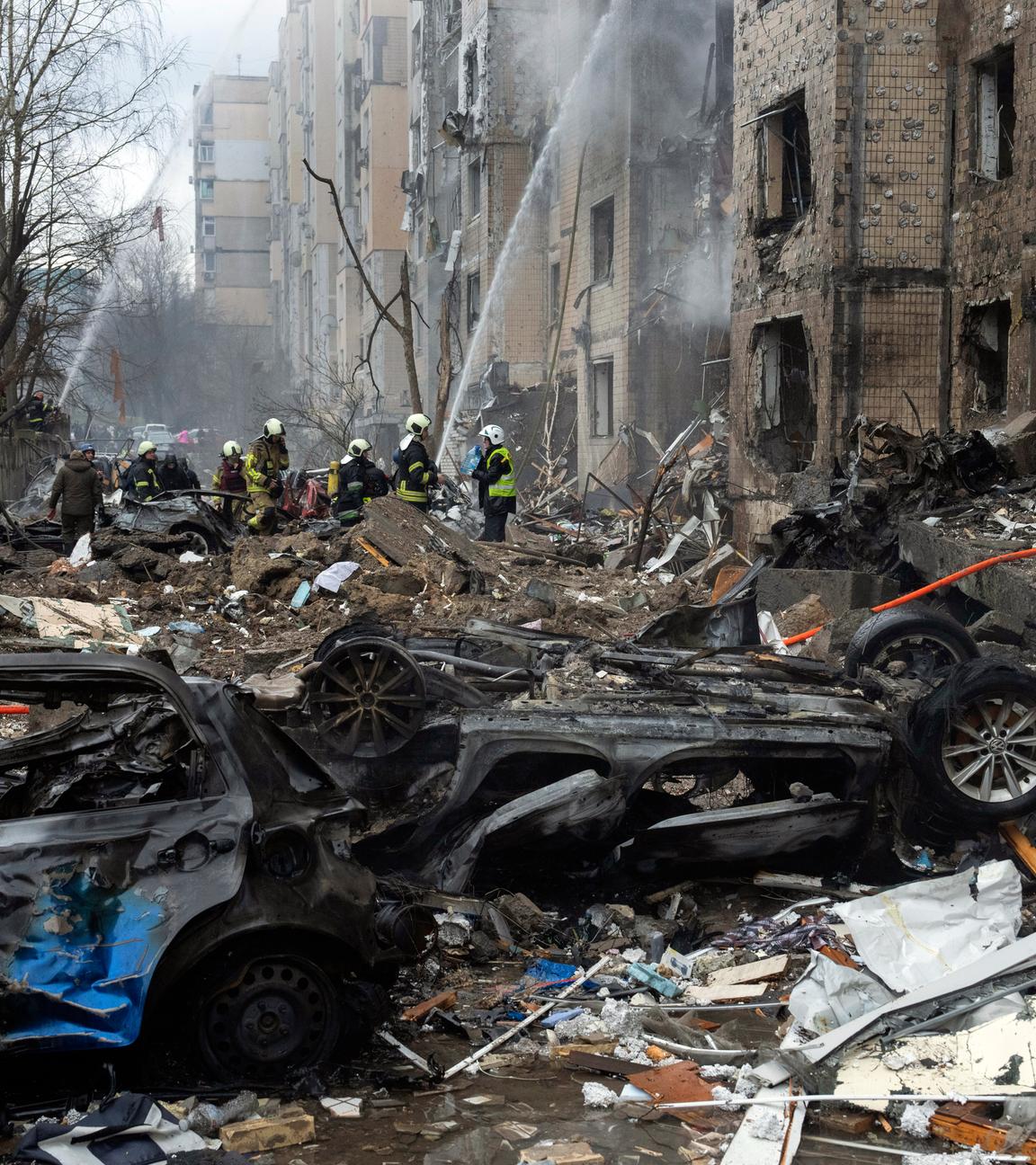  Ukraine, Kiew: Feuerwehrleute arbeiten daran, ein Feuer in einem zerstörten Wohnhaus nach einem russischen Raketenangriff zu löschen.