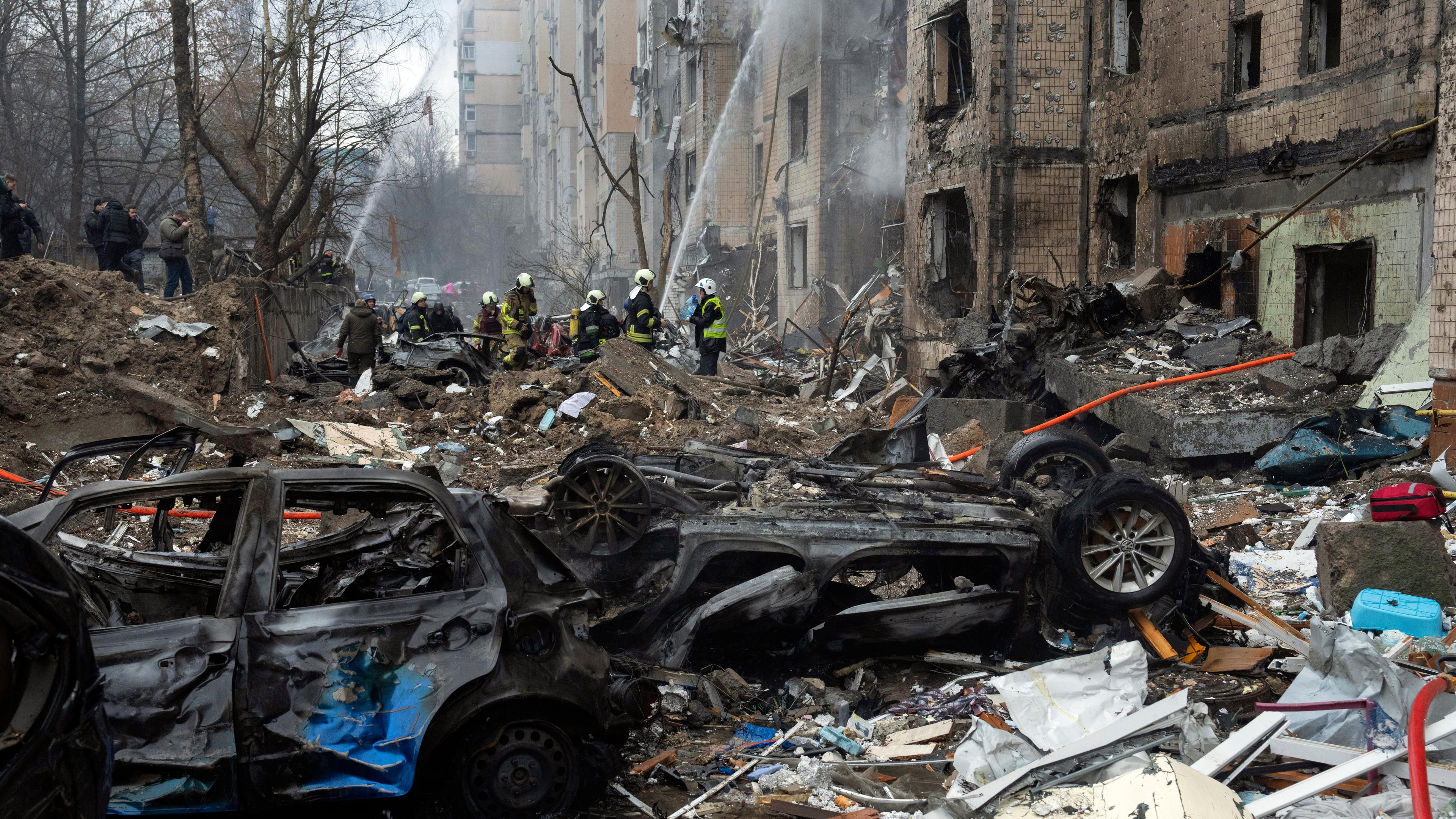  Ukraine, Kiew: Feuerwehrleute arbeiten daran, ein Feuer in einem zerstörten Wohnhaus nach einem russischen Raketenangriff zu löschen.