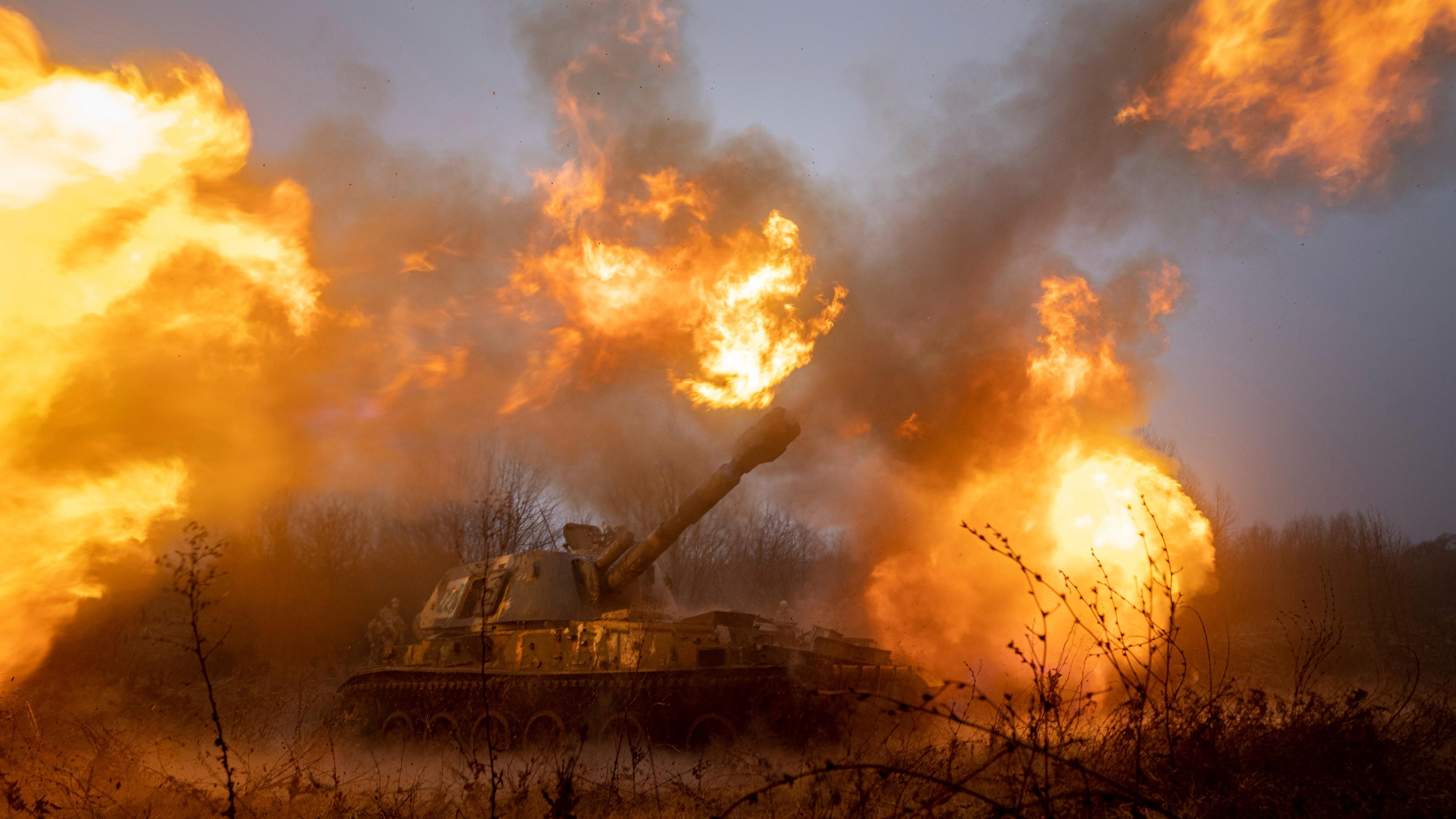 Ein Panzer schießt in brennendem Feld.