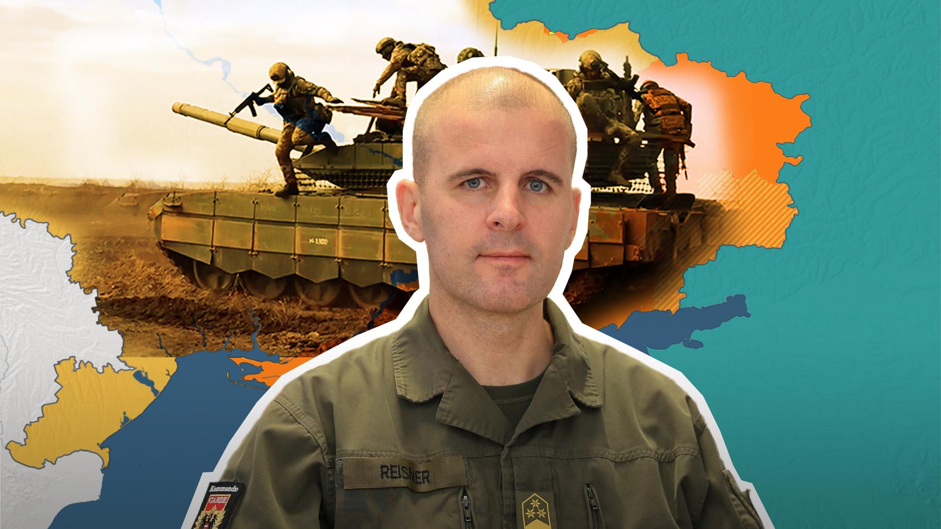 Oberst Markus Reisner ist vor einer Karte der Ukraine auf der ein Panzer abgebildet zusehen.