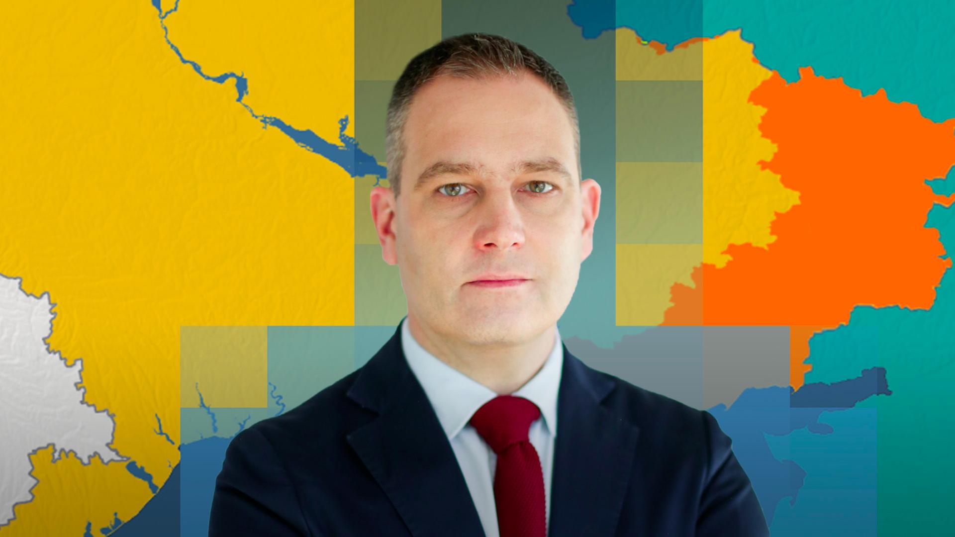 Militärexperte Gustav Gressel ist vor einer Karte der Ukraine mit aktuellem Frontverlauf abgebildet.