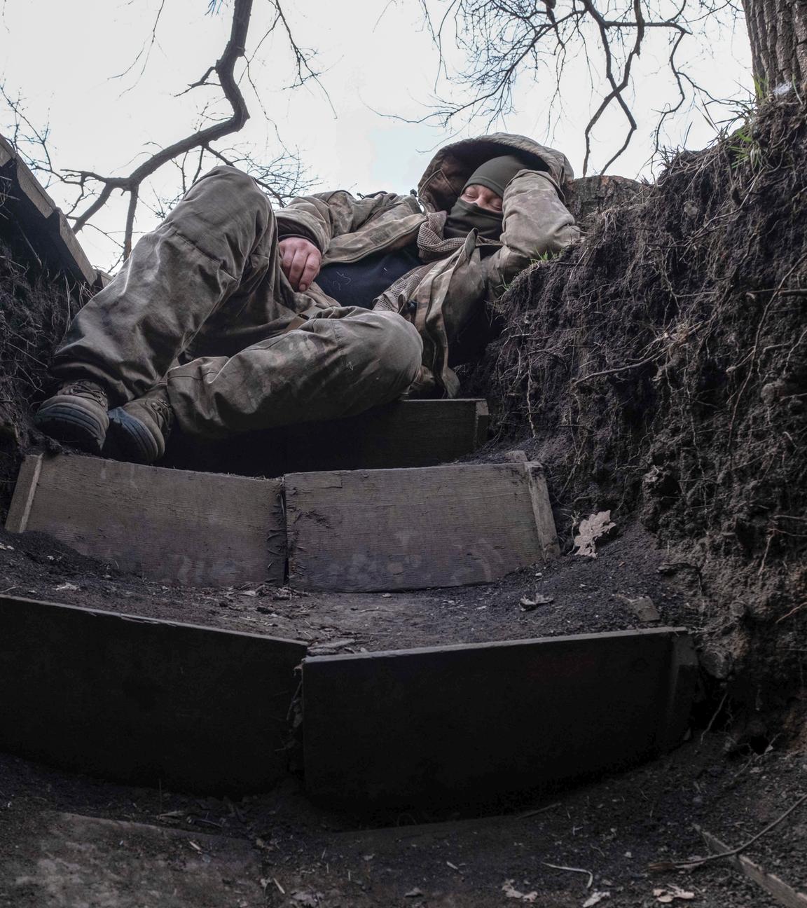 Ukraine, Lyman: Ein ukrainischer Soldat ruht sich in einem Schützengraben an der Frontlinie in der Nähe von Lyman aus.