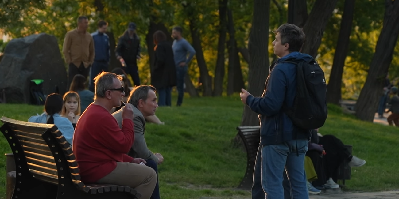 Eine Gruppe ukrainischer Männer steht im Park beisammen