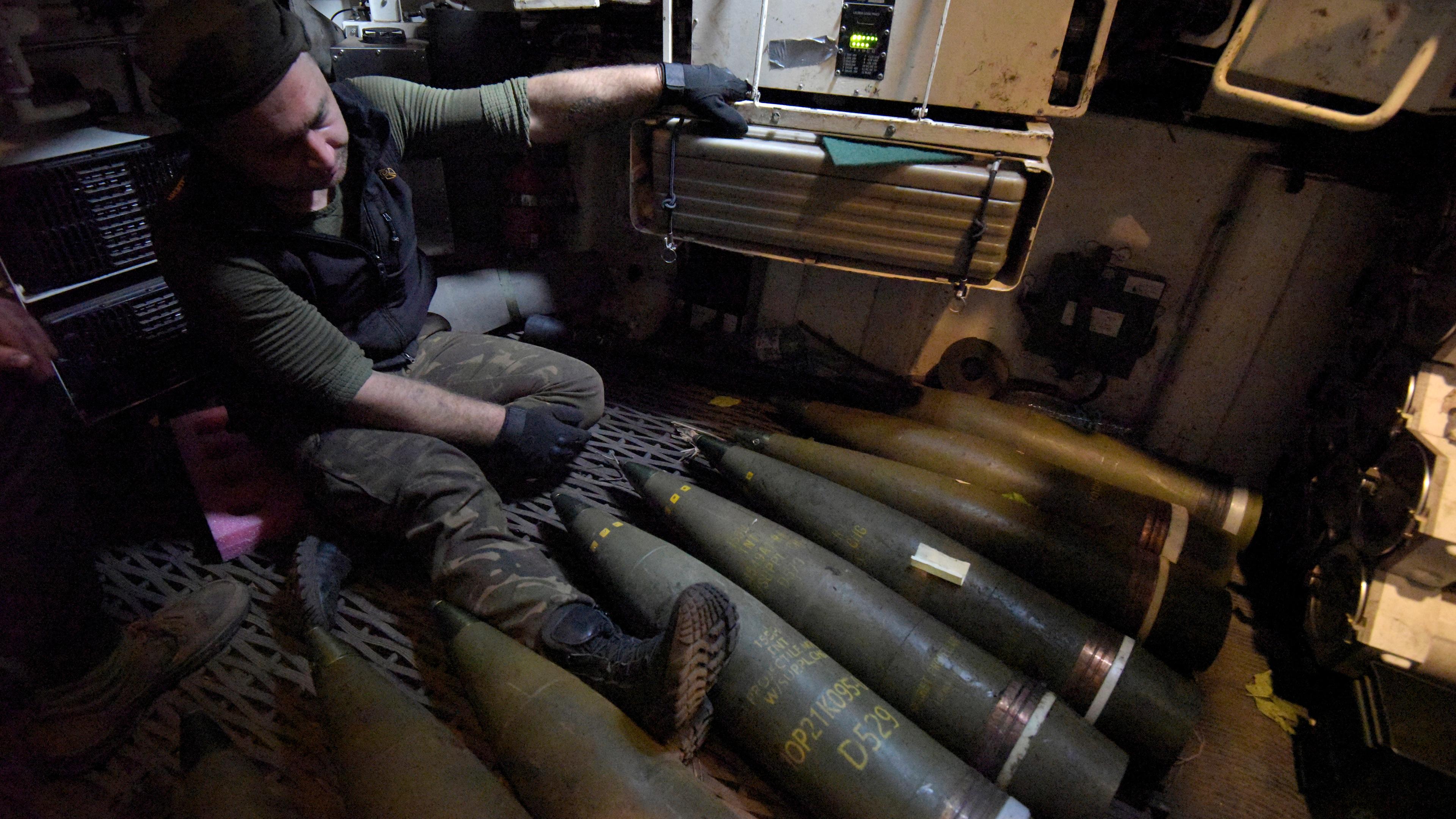 Ein ukrainischer Soldat sitzt neben Munition an Bord des polnischen selbstfahrenden gepanzerten Artilleriegeschützes AHS Krab.