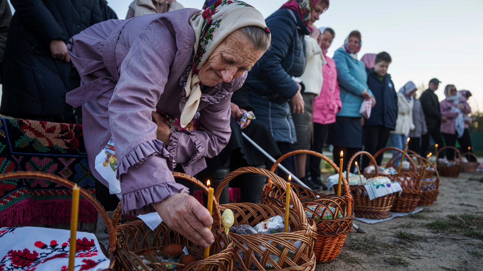 Eine ältere Frau bereitet ihre Osterkörbe für die Segnung während des orthodoxen Osterfestes im Dorf Krasne, Ukraine vor.