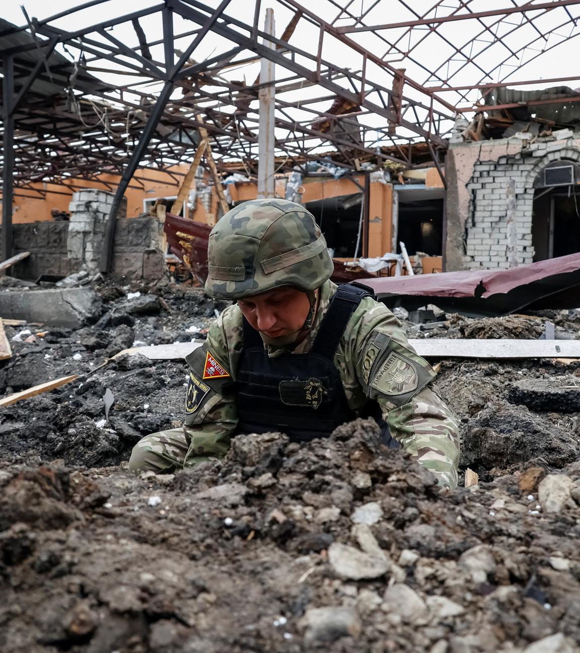 A Police bomb squad member works at the site of a Russian air strike, amid Russia's attack on Ukraine, in Kharkiv, Ukraine.