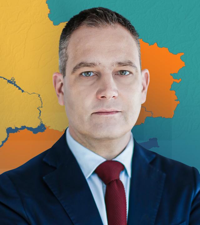 Militärexperte gustav gressel im Anzug vor einer Karte der Ukraine