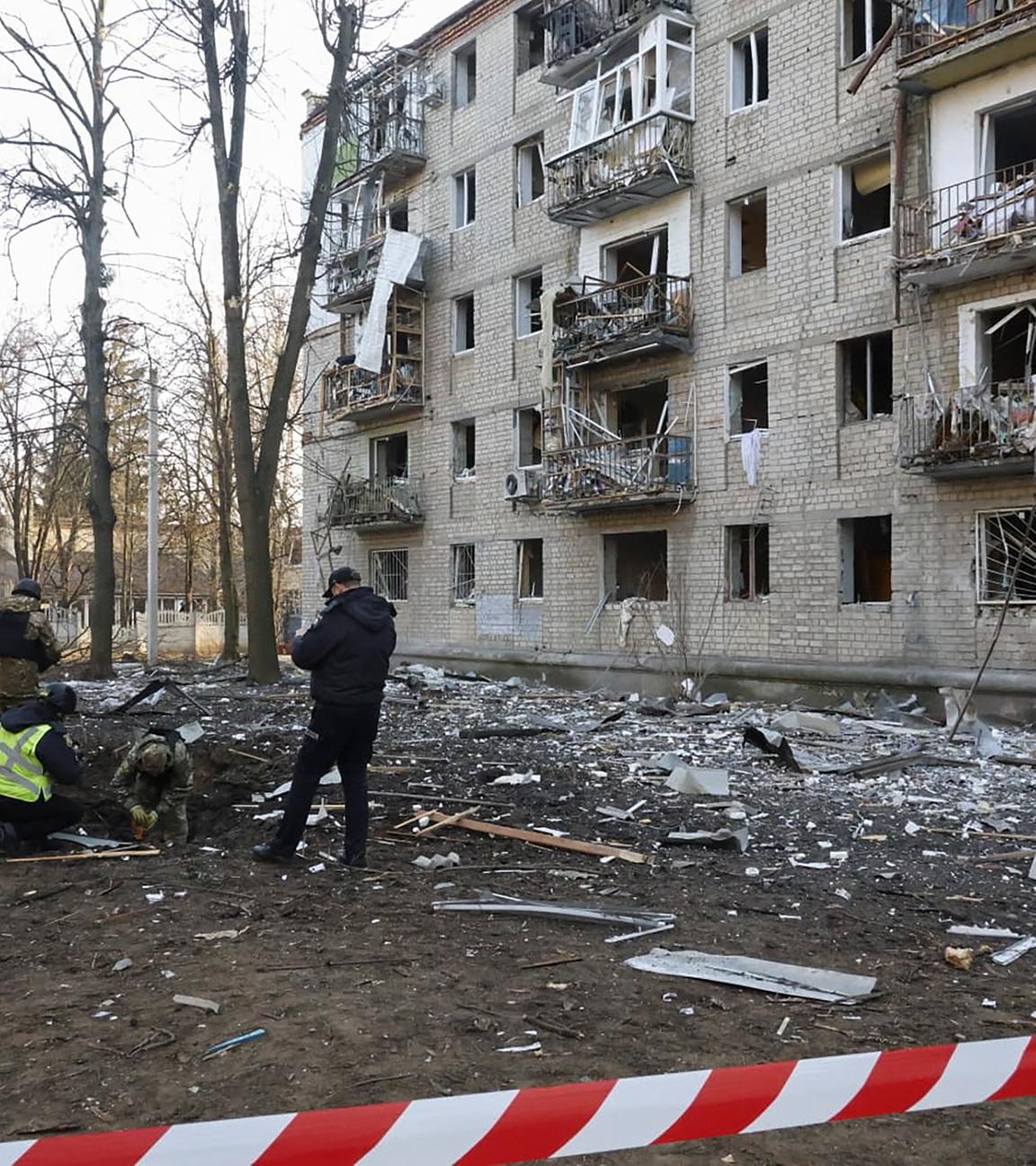 Polizei in Charkiw bei zerstörten Wohnhäusern.