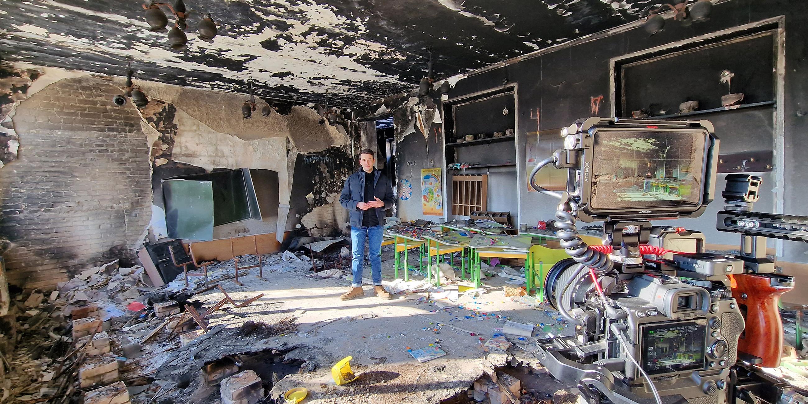 logo!-Reporter Sherif steht in einer zerstörten Schule in der Ukraine