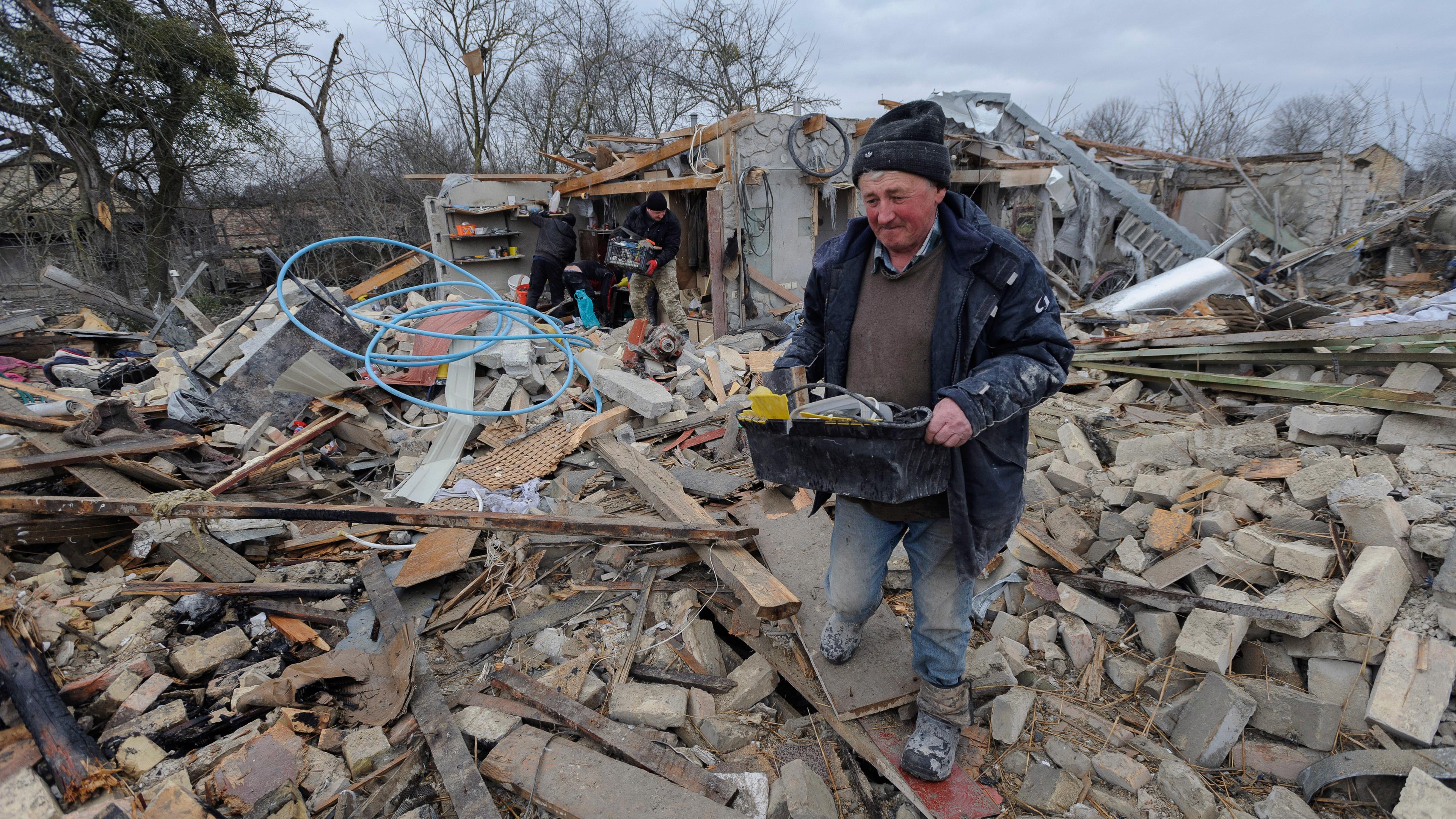 Dorfbewohner räumen die Trümmer nach einem nächtlichen Raketenangriff auf Privathäuser in Solotschiw in der Ukraine auf am 09.03.2023
