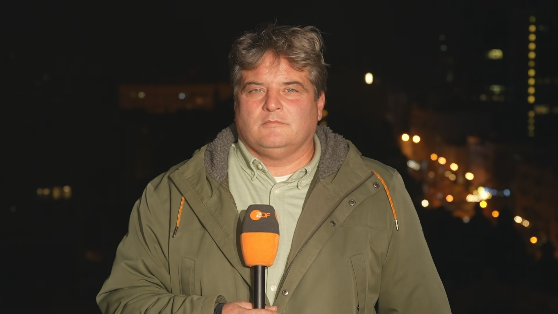 ZDF-Reporter Dara Hassanzadeh in Jacke gekleidet nachts in Kiew.