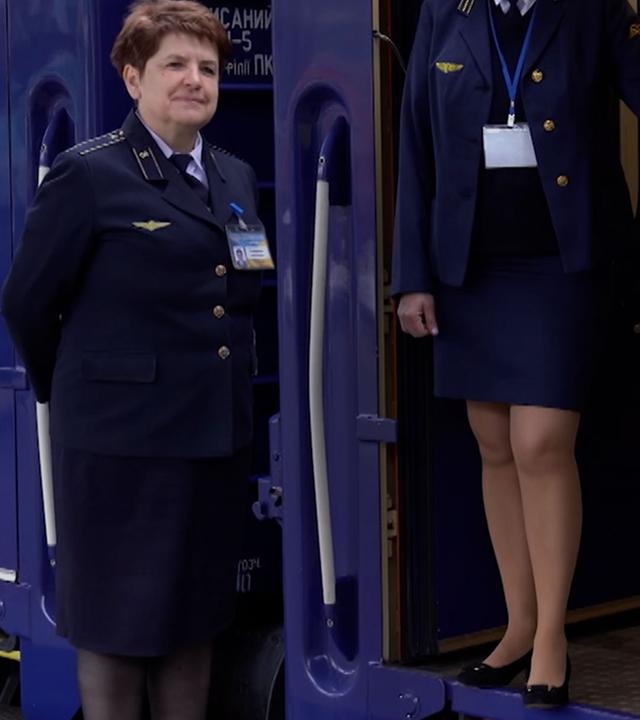 In der Ukraine stehen zwei Schaffnerinnen vor einem Zug