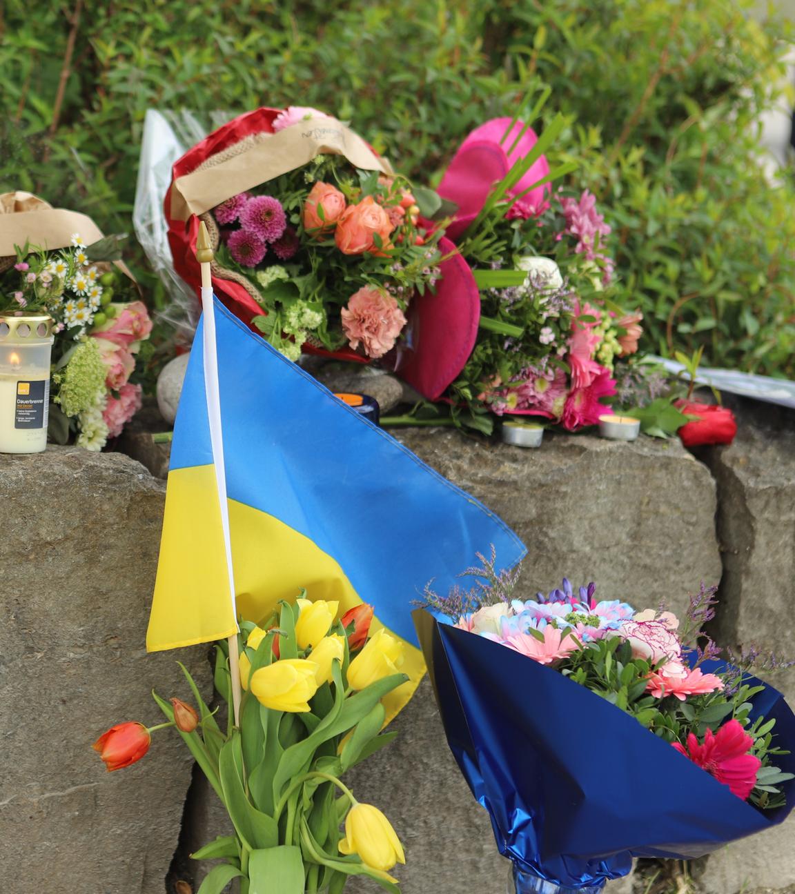  Am Gelände eines Einkaufszentrums, an dem am Samstagabend (27.04.2024) zwei Männer aus der Ukraine getötet worden sind, wurden Blumen niedergelegt, sowie eine kleine ukrainische Flagge aufgestellt.