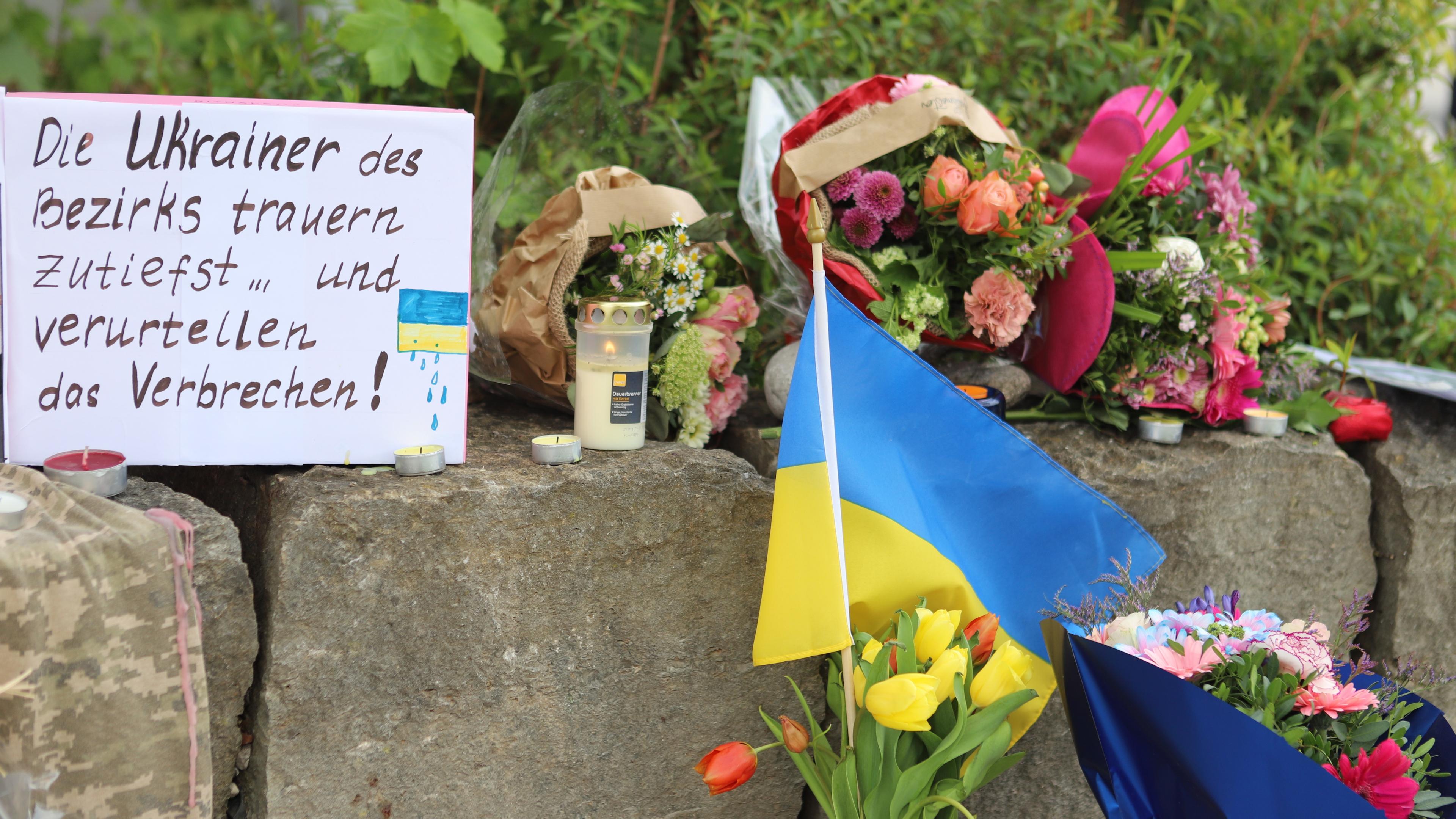  Am Gelände eines Einkaufszentrums, an dem am Samstagabend (27.04.2024) zwei Männer aus der Ukraine getötet worden sind, wurden Blumen niedergelegt, sowie eine kleine ukrainische Flagge aufgestellt.