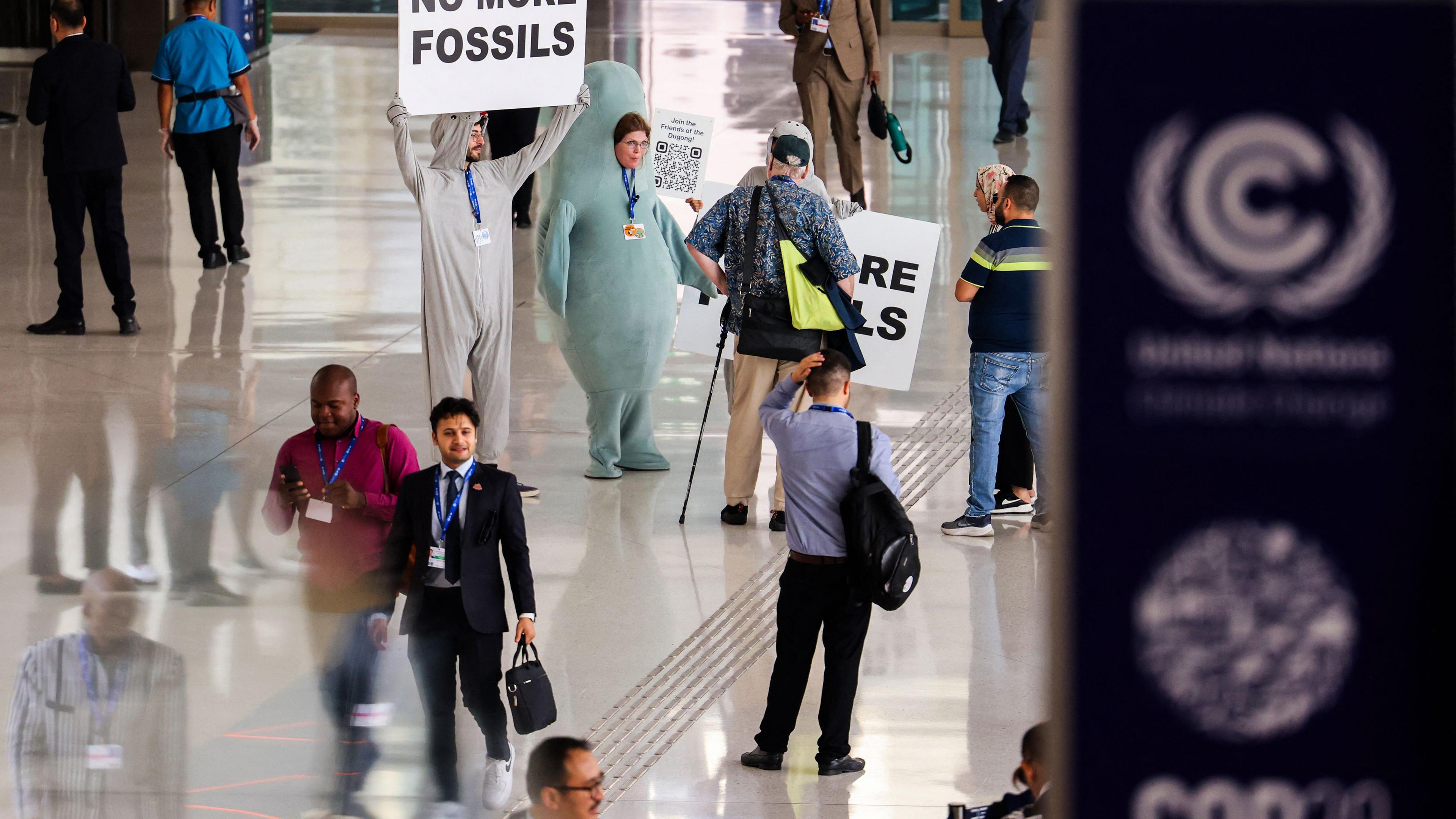 Umweltaktivisten zeigen während des Klimagipfels der Vereinten Nationen in Dubai am 05.12.2023 Plakate.