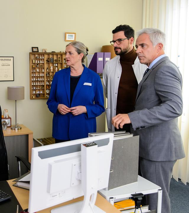 "Bettys Diagnose - ...und du bist raus": Lukas (Niklas Löffler) und Betty (Annina Hellenthal) stehen zusammen im Büro von Mechthild Puhl (Sybille J. Schedwill). Sie, Dr. Tom Koopmann (Tobias Licht) und Prof. Dr. Alexander von Arnstett (Florian Fitz) stehen den beiden gegenüber und schauen sie fragend und fordern an.