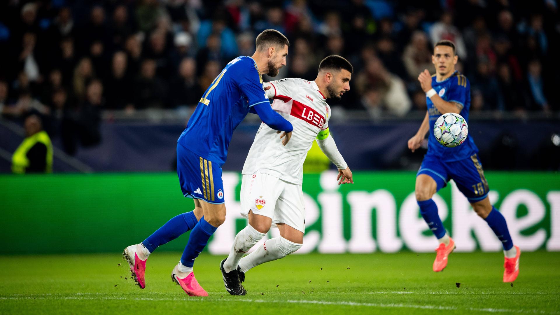 Der Stuttgarter Stürmer Deniz Undav wird im Champions-League-Spiel gegen den SK Slovan Bratislava von seinem Gegenspieler Svetozar Marković von hinten bedrängt.