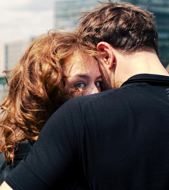 Christoph hält Undine im Arm. Sie blickt über seine Schulter in die Kamera.