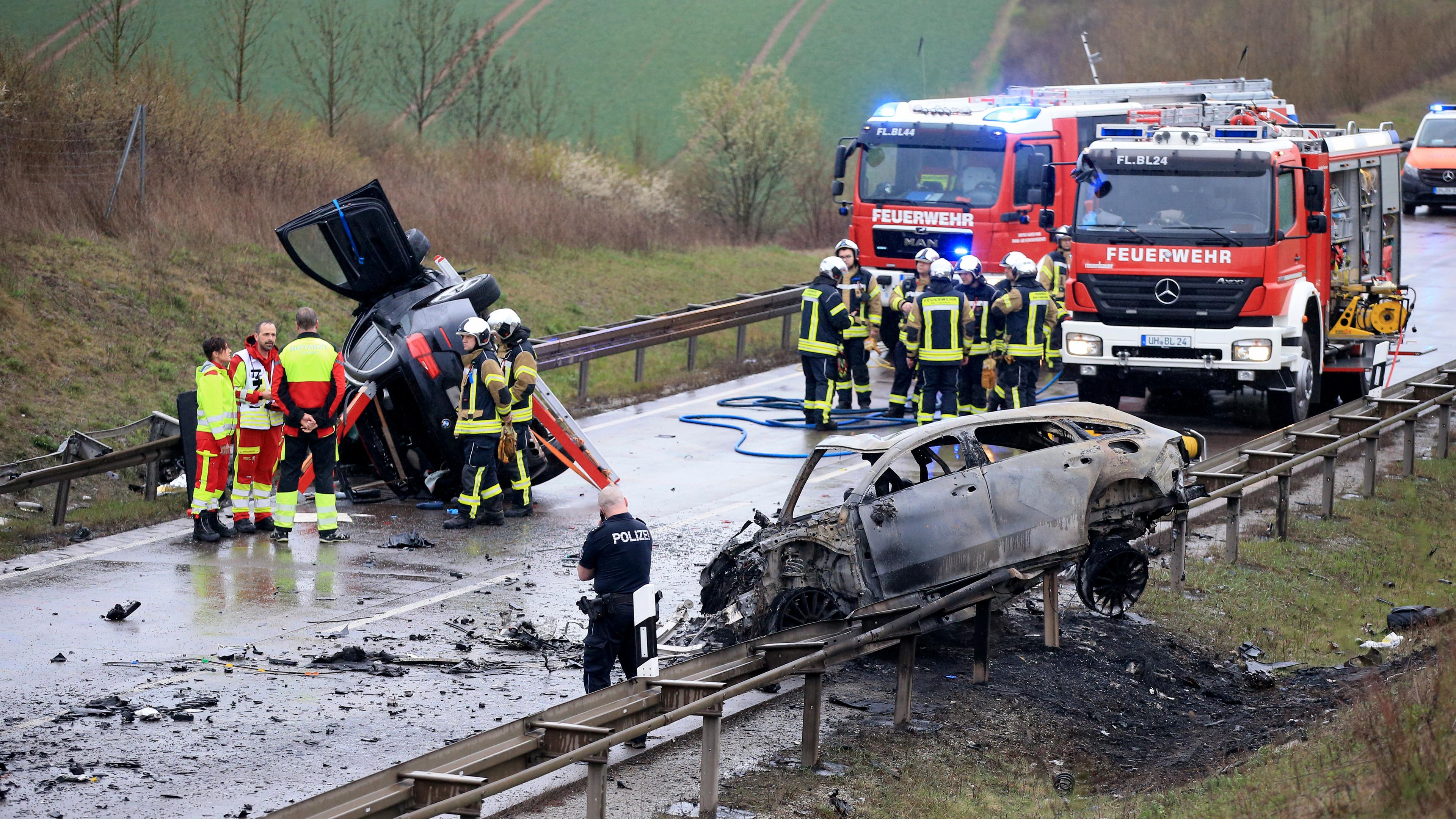 Ein ausgebrannter PKW und ein weiteres verunfalltes Fahrzeug stehen an der Unfallstelle auf der B247 bei Bad Langensalza.