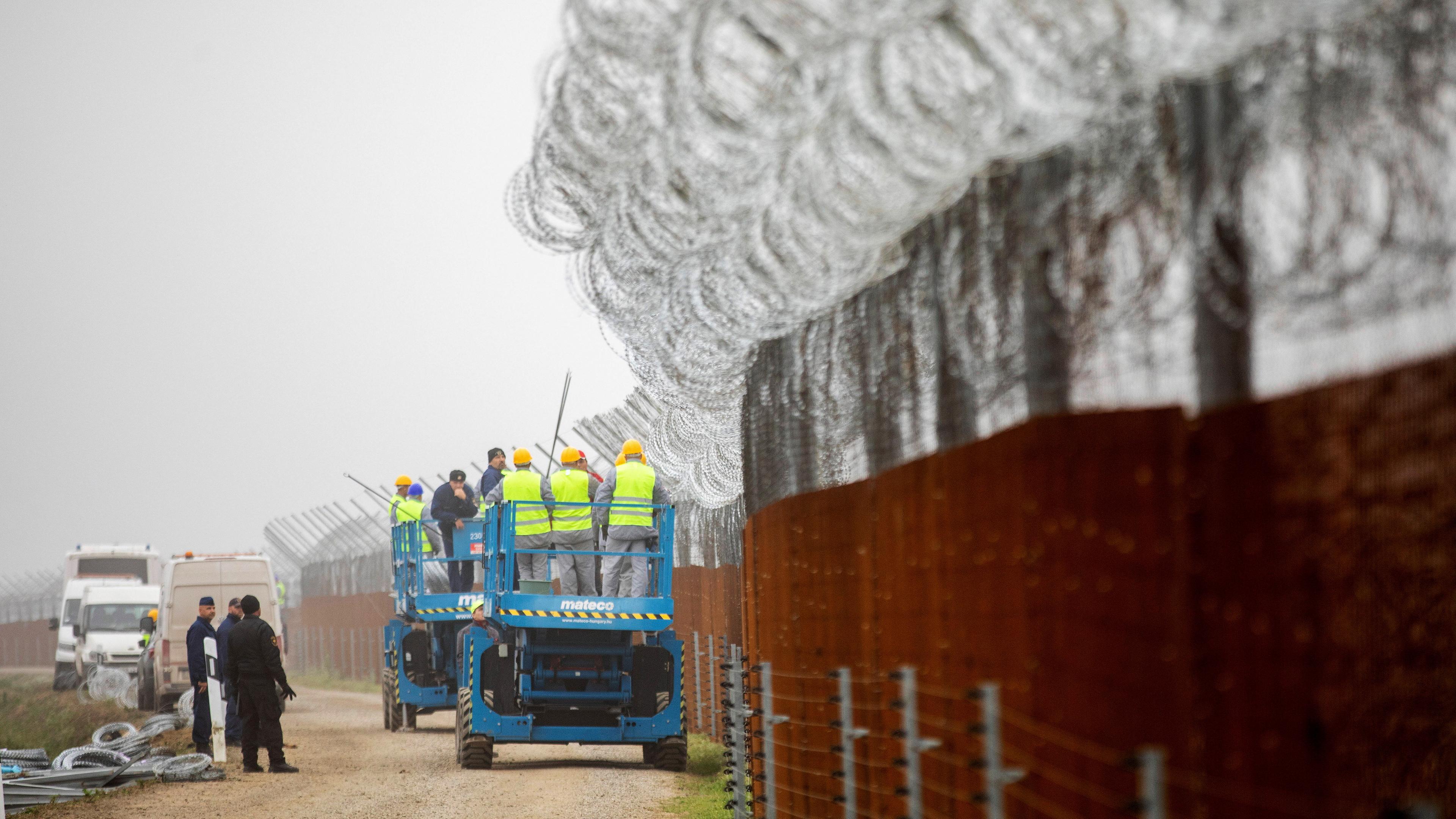 Arbeiter befestigen Stacheldraht am Zaun entlang der ungarischen Grenze zu Serbien in der Stadt Roszke, aufgenommen am 28.10.2022