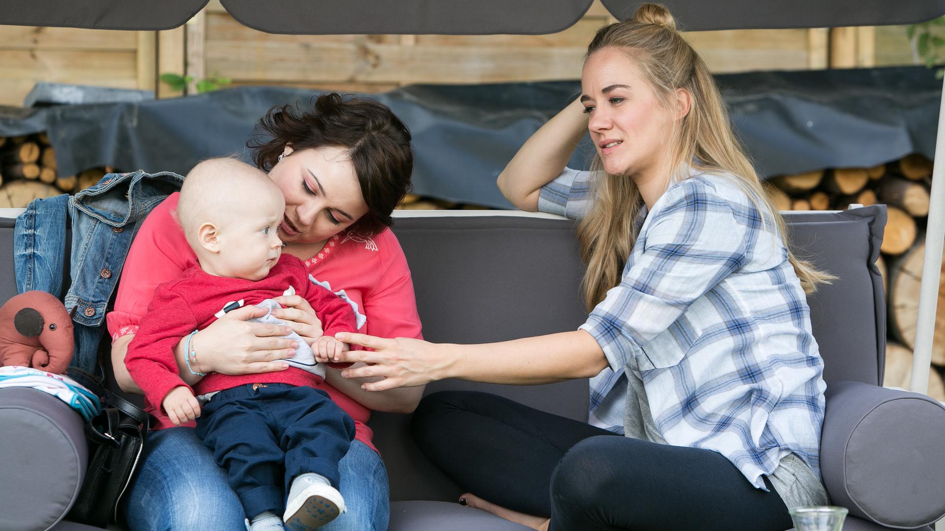 "Bettys Diagnose - Ungeahnte Perspektiven": Talula Pfeifer (Carolin Walter) und Betty Weiss (Annina Hellenthal) sitzen mit Baby Emil auf der Hollywoodschaukel im Garten.