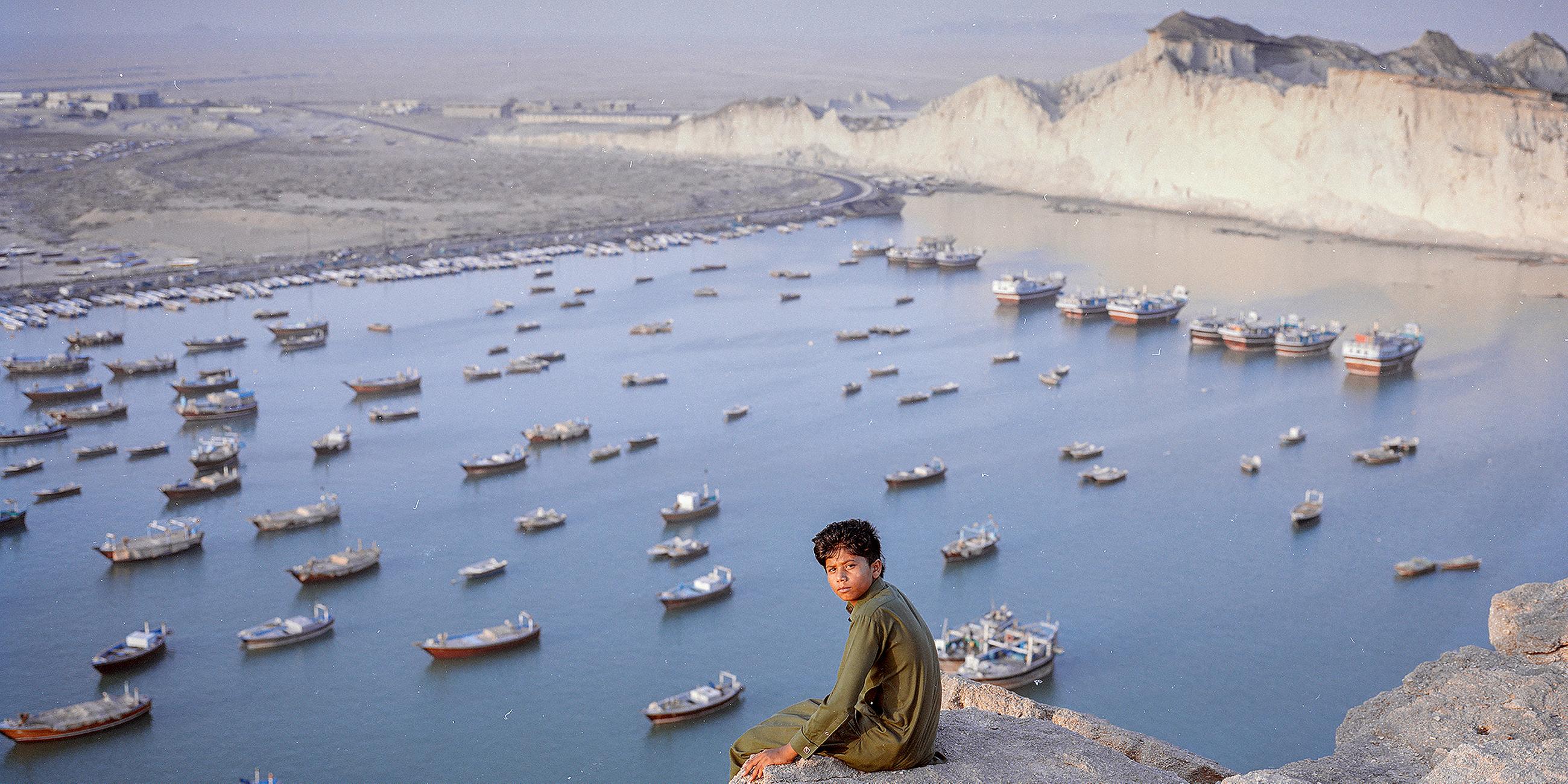Der 13-jährige Hossein sitzt vor dem Hamun-See im Iran.