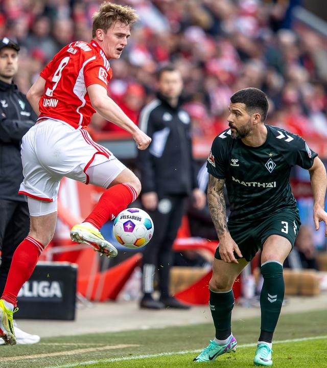  Berlins Mikkel Kaufmann (l) springt zum Ball gegen Anthony Jung von Werder Bremen.
