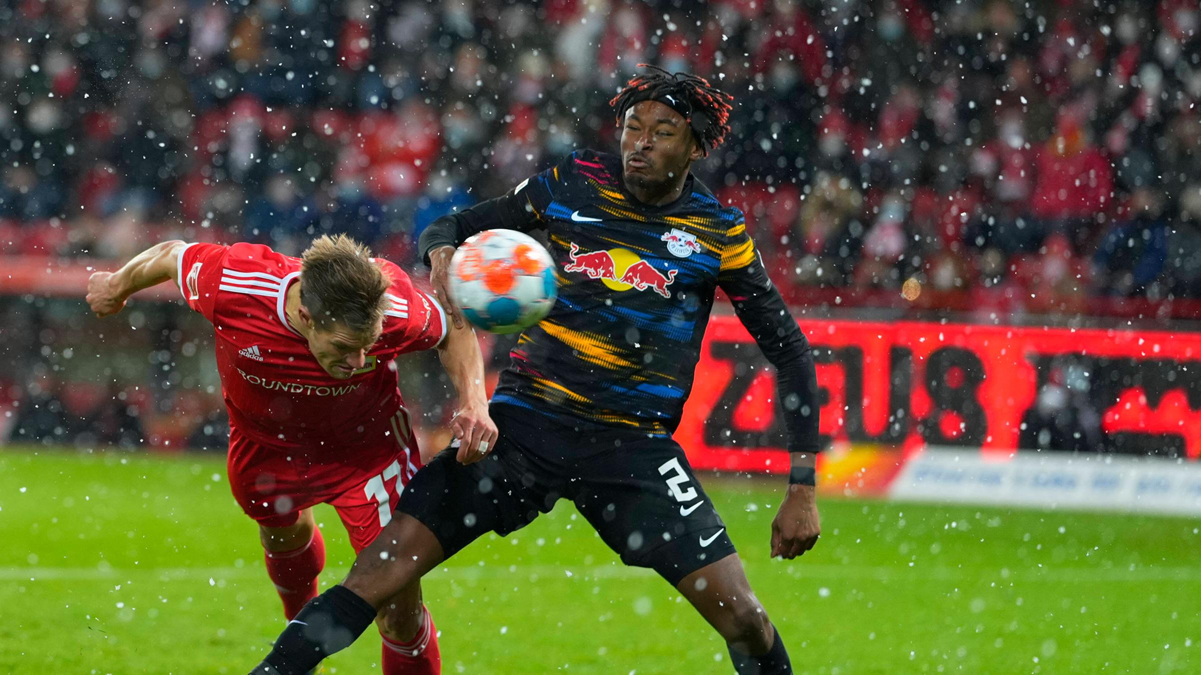 Kevin Behrens (Union Berlin) kämpft mit einem Gegenspieler von RB Leipzig um den Ball.