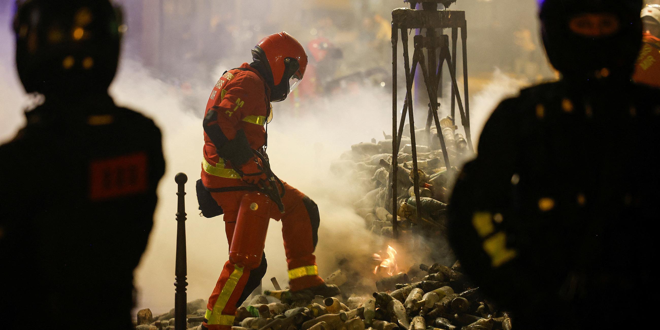 Feuerwehrmann tritt auf Flammen eines Containers in Paris (01.07.2023)