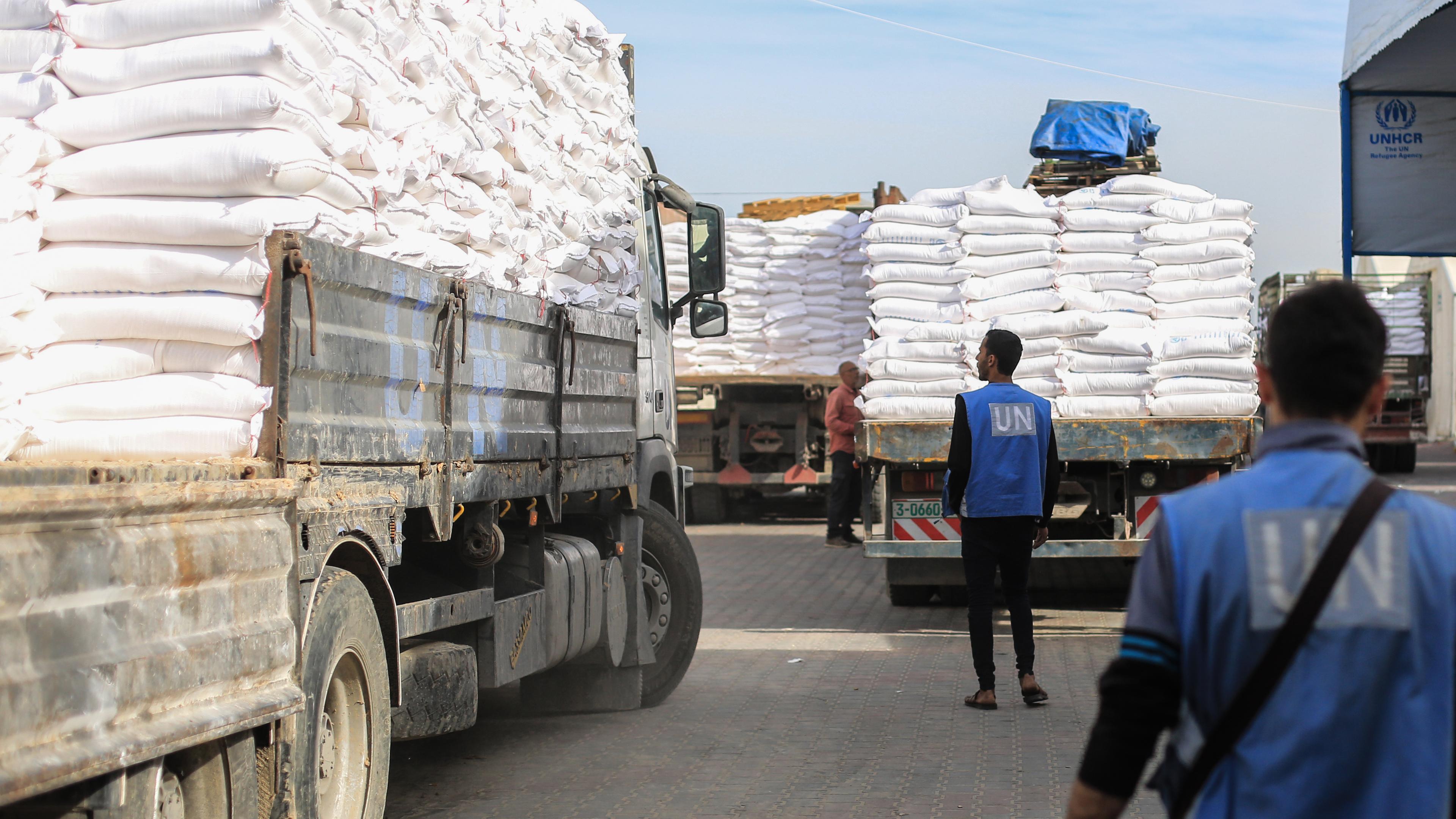 Zwei Mitarbeiter laden Mehlsäcke auf einen Lastwagen im Verteilungszentrum des Hilfswerks der Vereinten Nationen für Palästinaflüchtlinge (UNRWA)
