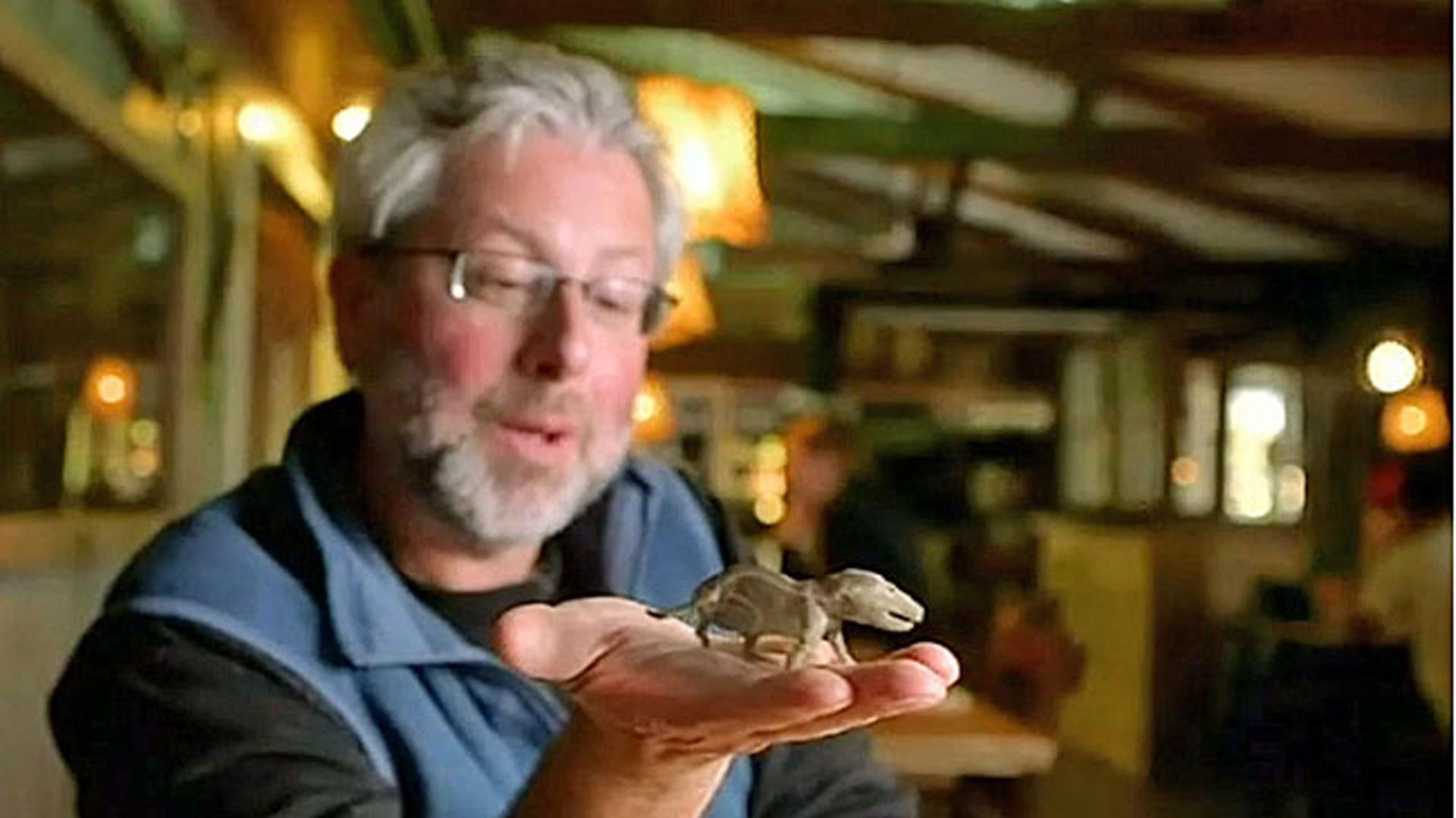 "Unsere geheimen Vorfahren (2) Das Reptil in uns": Animierter kleiner Dinosaurier auf der Hand eines Mannes.