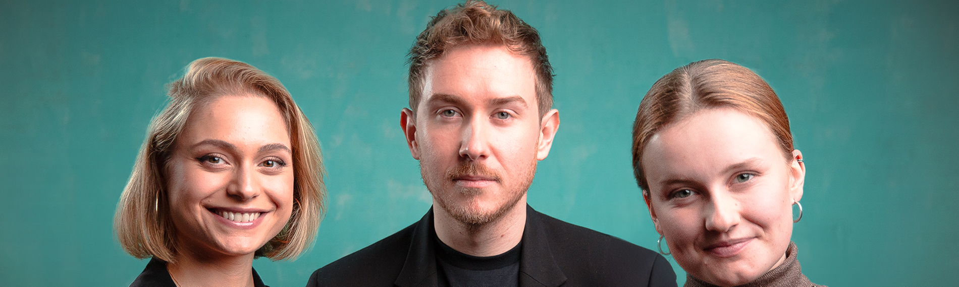 Drei Menschen stehen nebeneinander und schauen in die Kamera: Links eine blonde, lächelnde Frau, in der Mitte ein Mann, rechts eine blonde lächelnde Frau. Der Hintergrund ist grün.