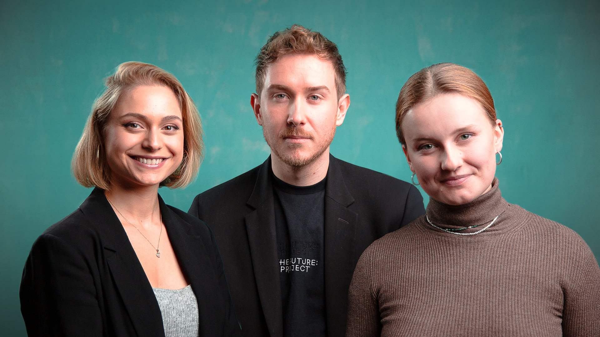 Drei Menschen stehen nebeneinander und schauen in die Kamera: Links eine blonde, lächelnde Frau, in der Mitte ein Mann, rechts eine blonde lächelnde Frau. Der Hintergrund ist grün.