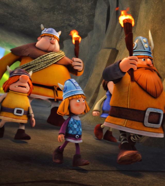Wickie, Snorre, Faxe und Halvar laufen mit Fackeln durch eine Höhle.