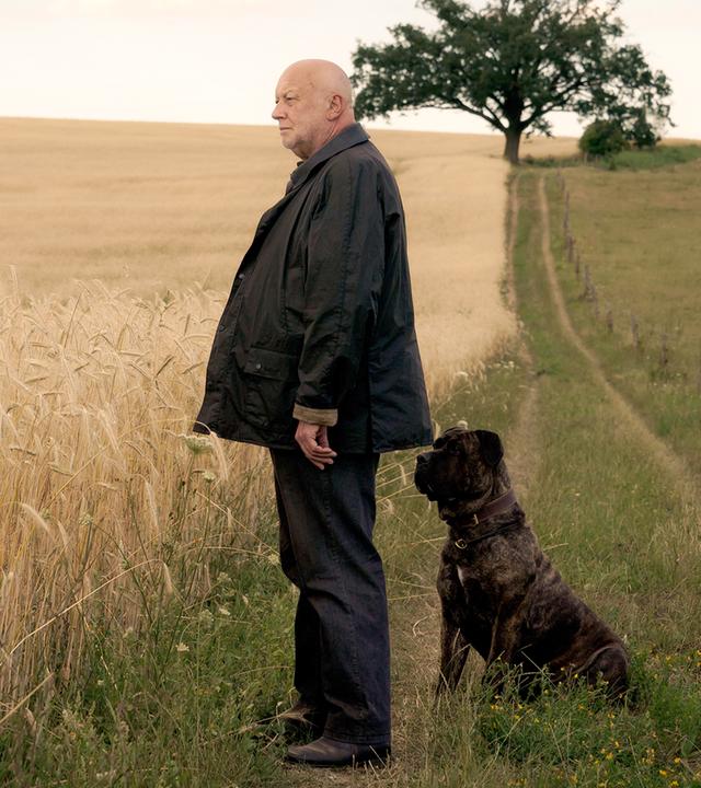 Rudolf Gombrowski steht mit seinem Hund vor den Feldern.
