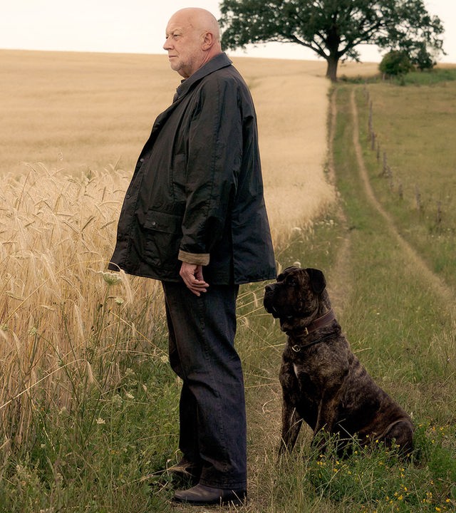 Rudolf Gombrowski steht mit seinem Hund vor den Feldern.
