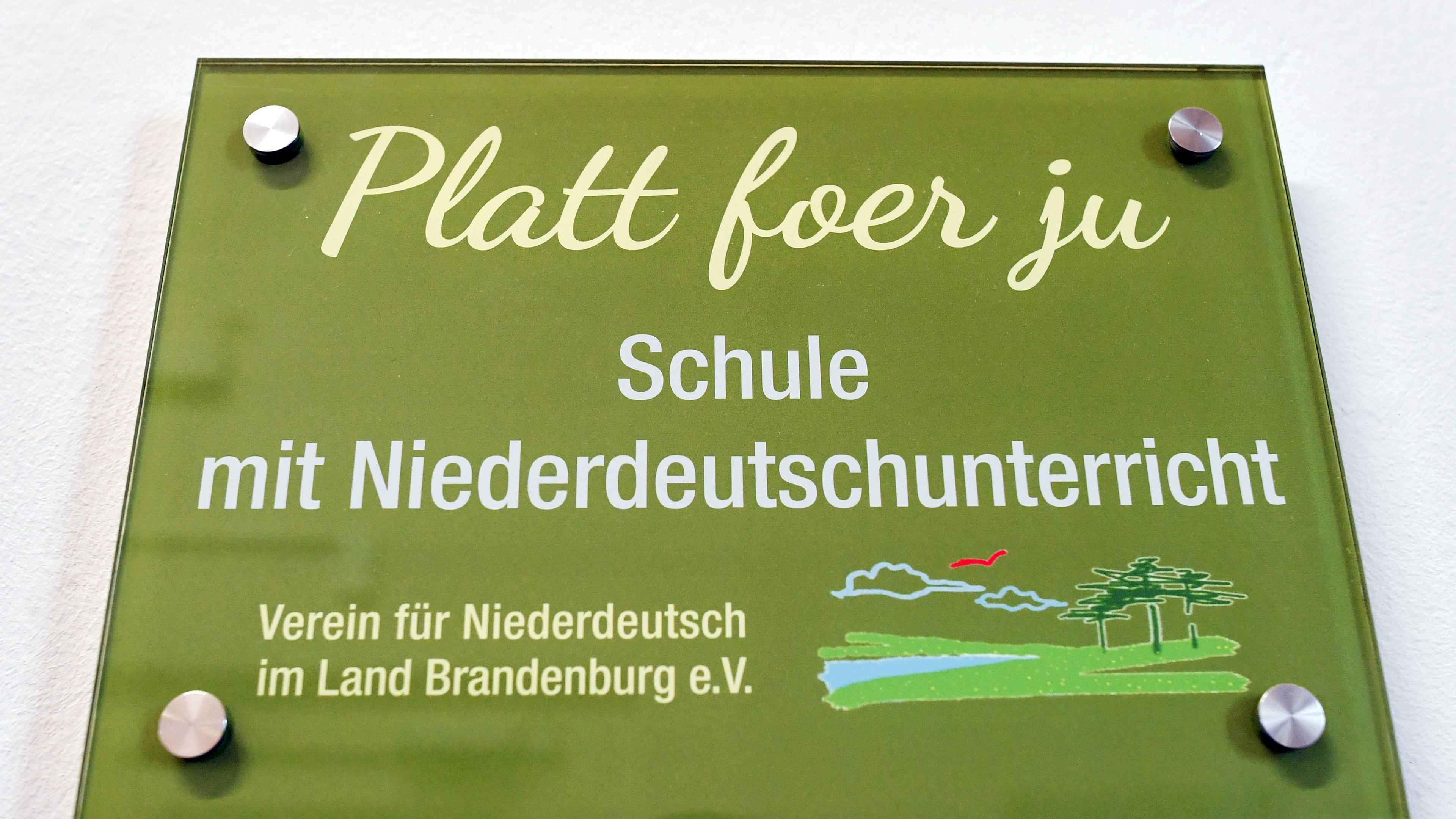 Ein Schild mit der Aufschrift "Platt foer ju - Schule mit Niederdeutschunterricht"