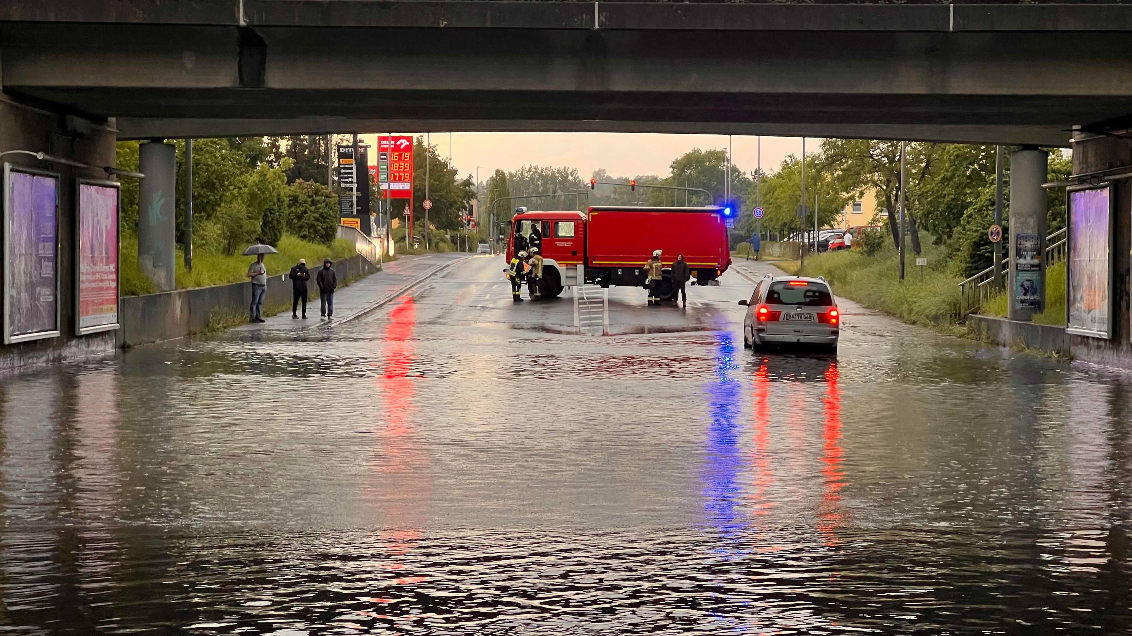 Ein Einsatzfahrzeug der Feuerwehr sichert eine mit Regenwasser vollgelaufene Unterführung ab am 02.05.2024.