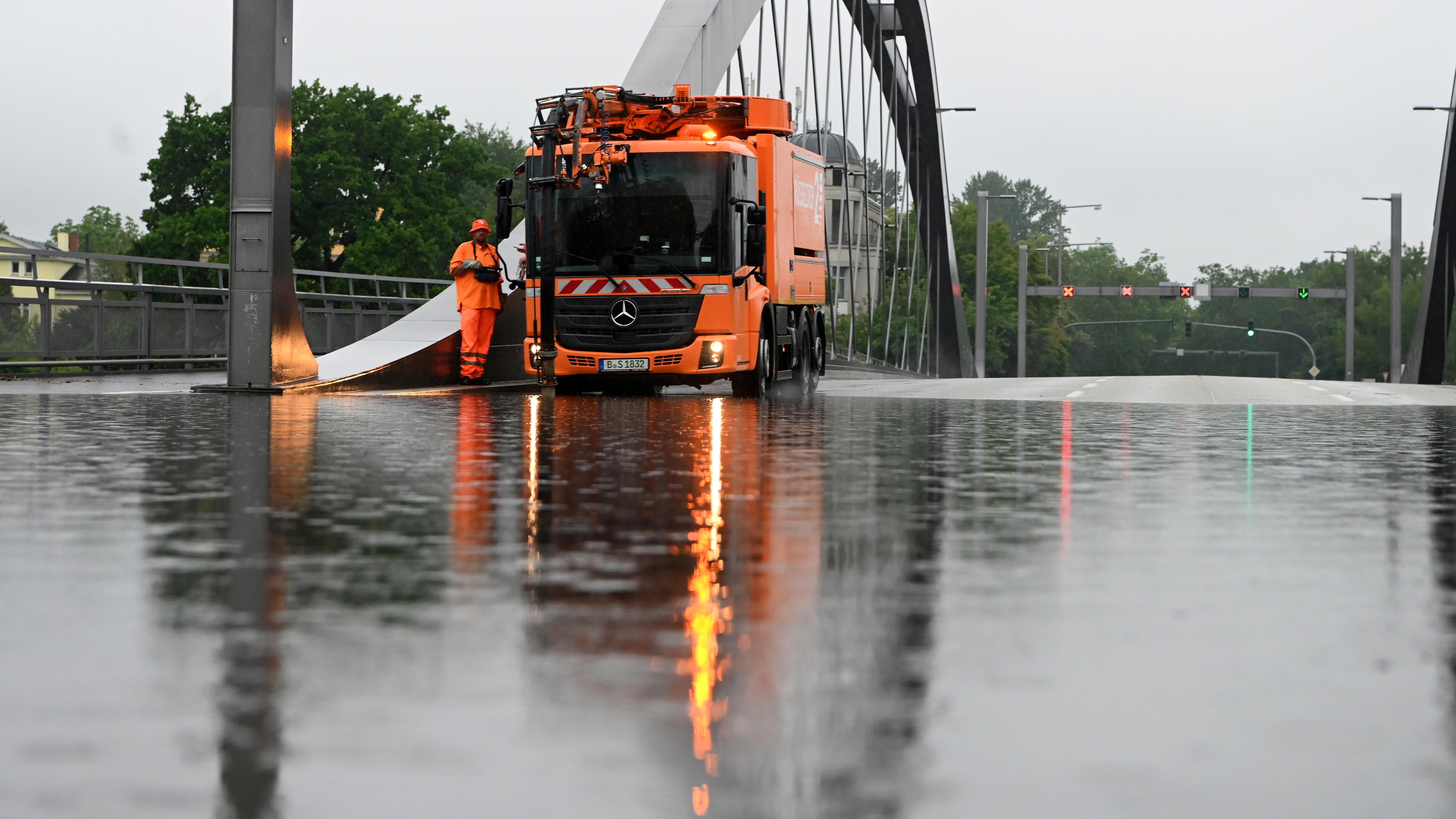 Ein Abpumpfahrzeug der Berliner Stadtreinigung BSR steht auf der überfluteten Freybrücke an der Heerstraße, aufgenommen am 22.06.2023