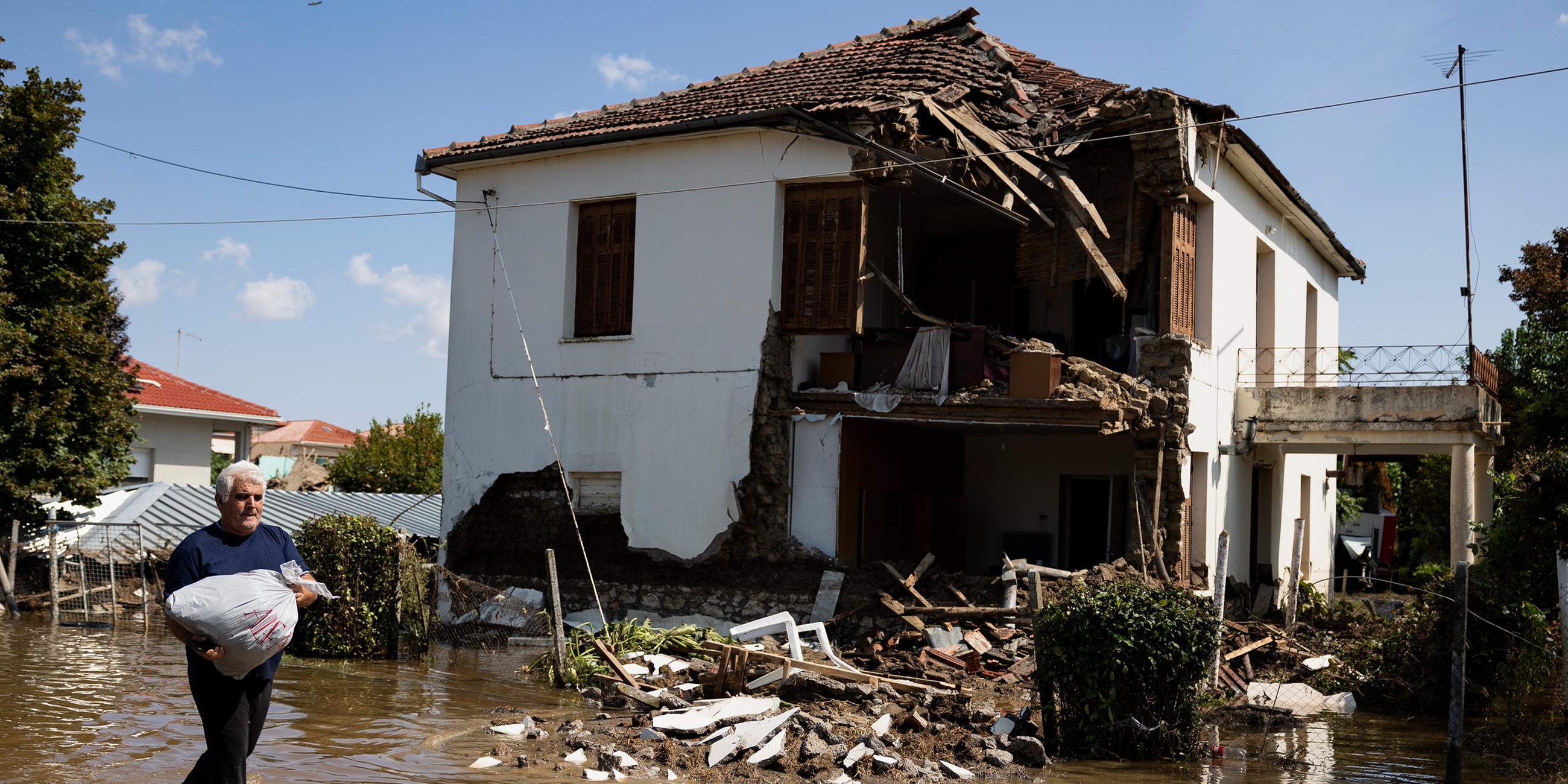 Ein Mann geht vor einem zerstörten Haus im überschwemmten Dorf Palamas nahe der Stadt Karditsa entlang. (08.09.2023)