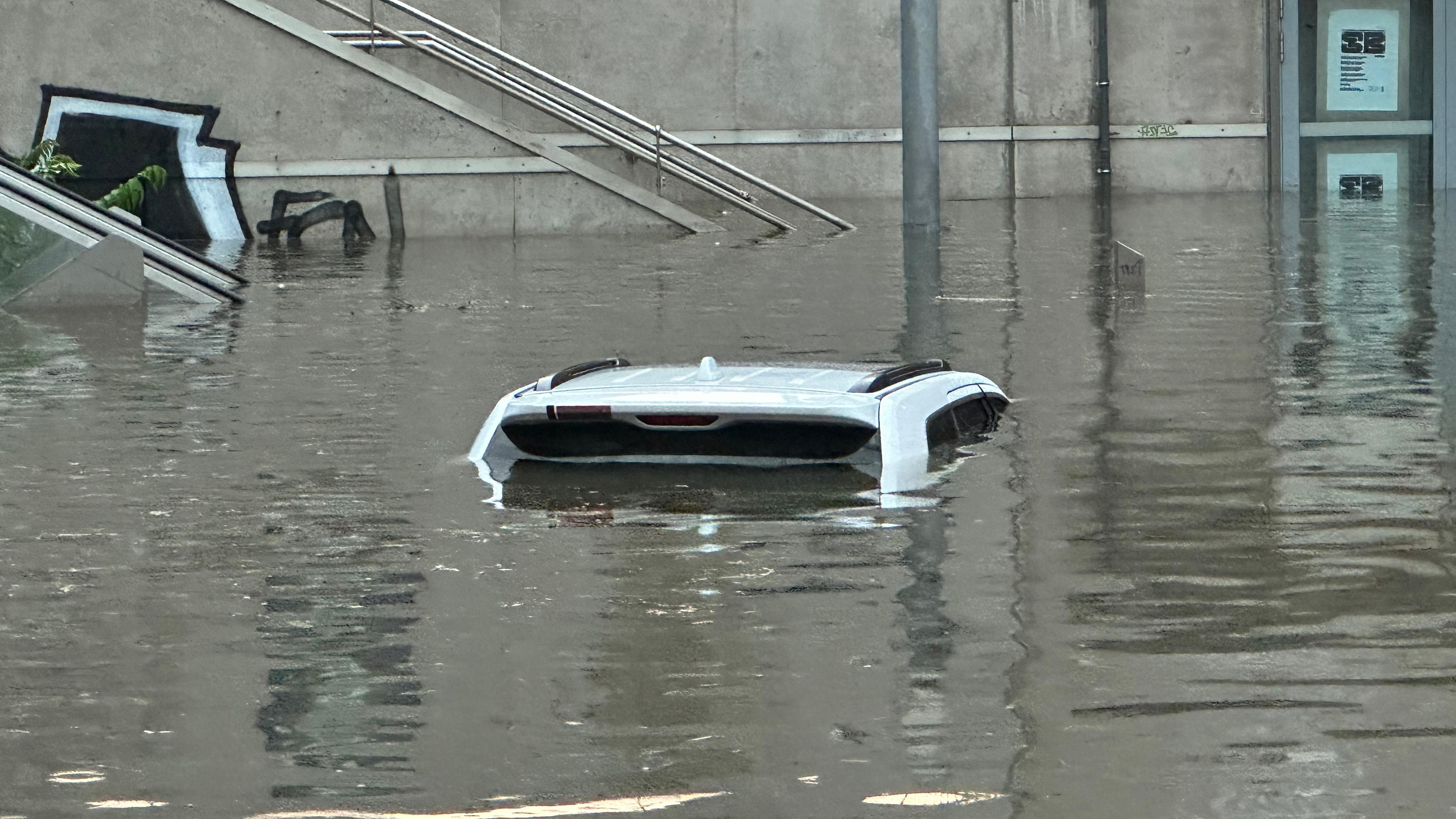  Ein Auto, von dem man nur das Dach erkennen kann, steht in einer überschwemmten Straße an einer Unterführung nach Unwetter in Nürnberg