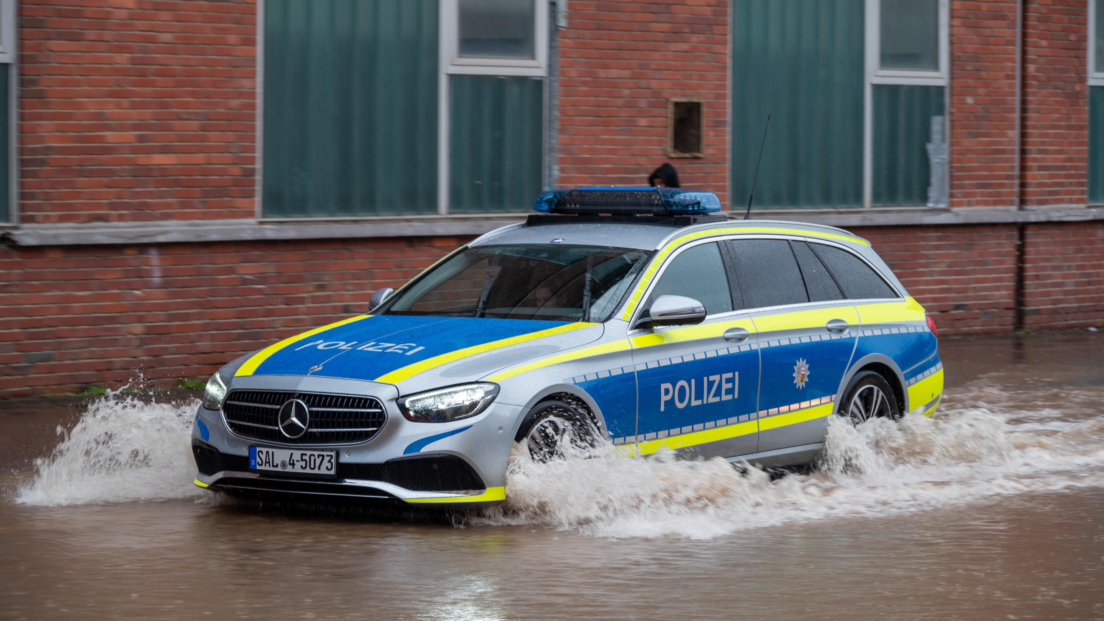 Ein Polizeifahrzeug fährt durch eine überflutete Straße in Saarbrücken