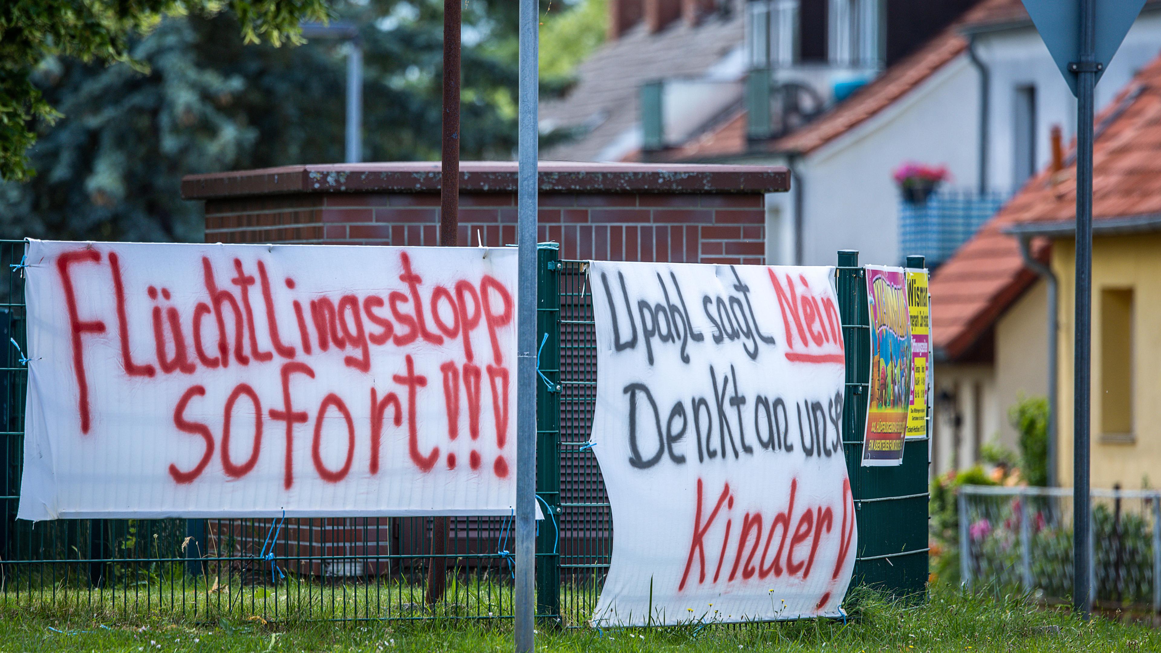 Mecklenburg-Vorpommern, Upahl: Protesttransparente gegen eine geplante Flüchtlingsunterkunft hängen an der Straße im Ortskern. 