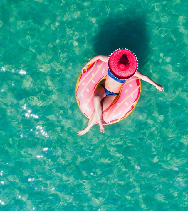 Frau sitzt in einem Luftkissen im Pool