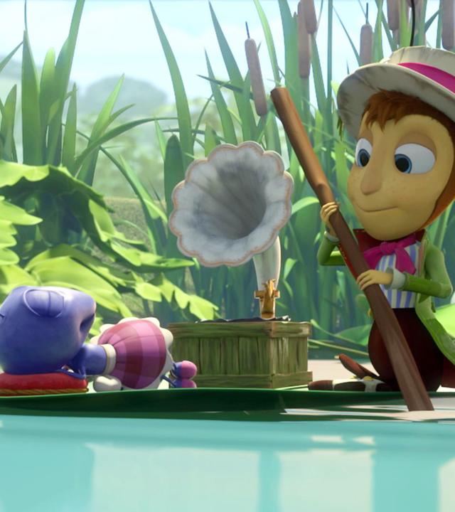 Ameise Anna (links) und Grille Gregor (rechts) lassen sich auf einem Blatt über den Teich gleiten. Anna liegt auf dem Rücken, die Arme hinter dem Kopf verschränkt, und Gregor nutzt einen Zweig als Paddel. Auf dem Blatt steht auch ein Grammophon.