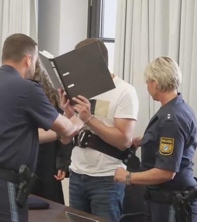 Auf dem Bild zu sehen ist: der Täter, der ein Buch vor sich hält.
